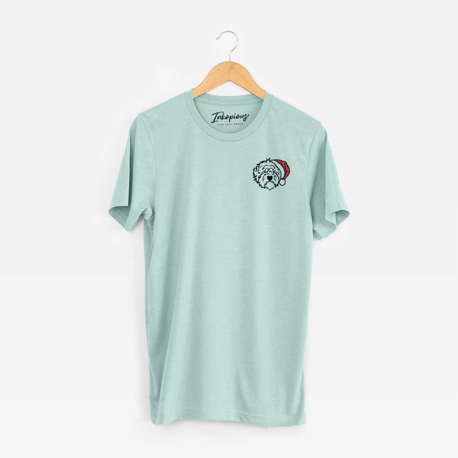 Small chest-pocket minimalist line drawing of Penny the Old English Sheepdog wearing a Santa hat on a Heather Sage Unisex crewneck
