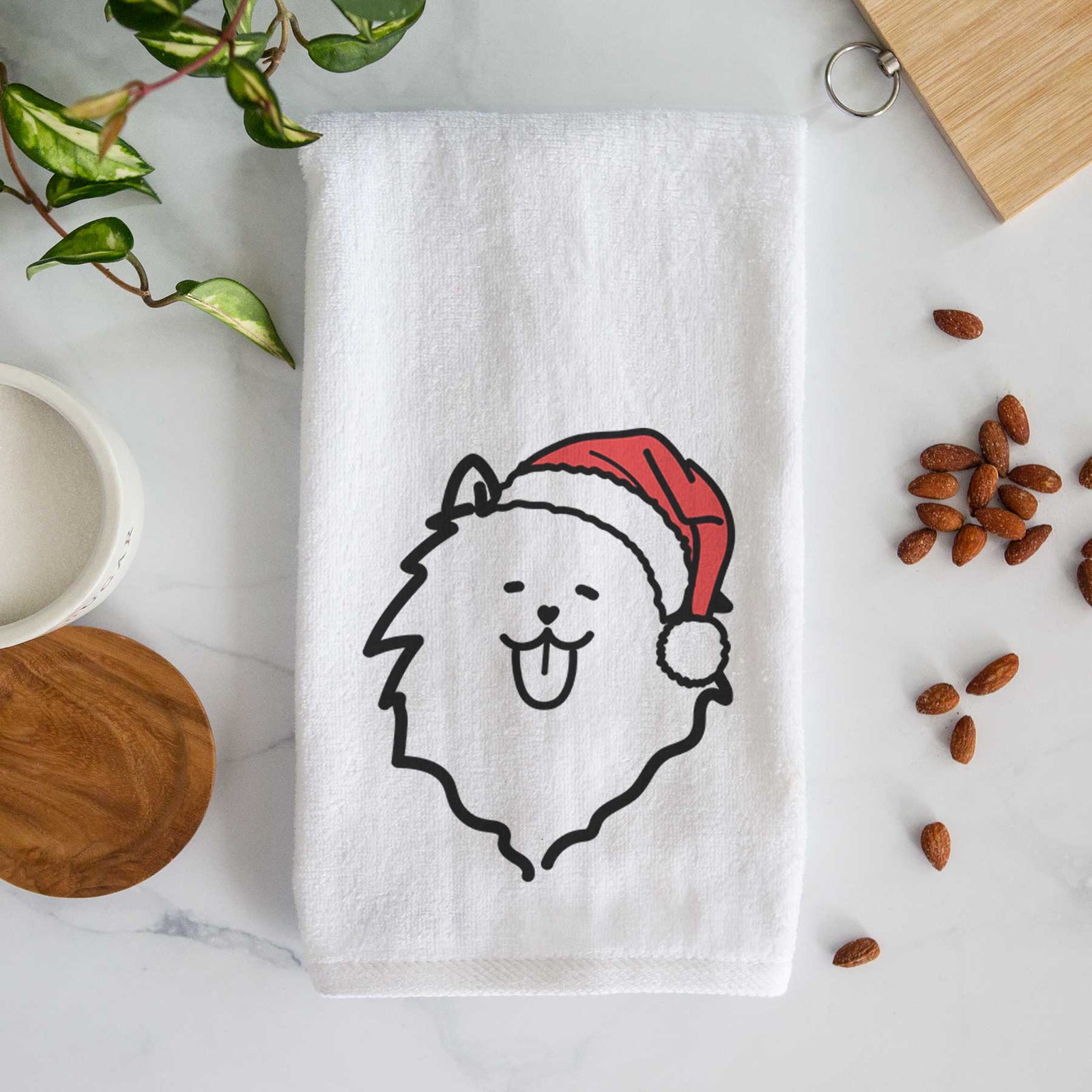 Minimalist line drawing of a Pomeranian wearing a Santa hat on a decorative hand towel