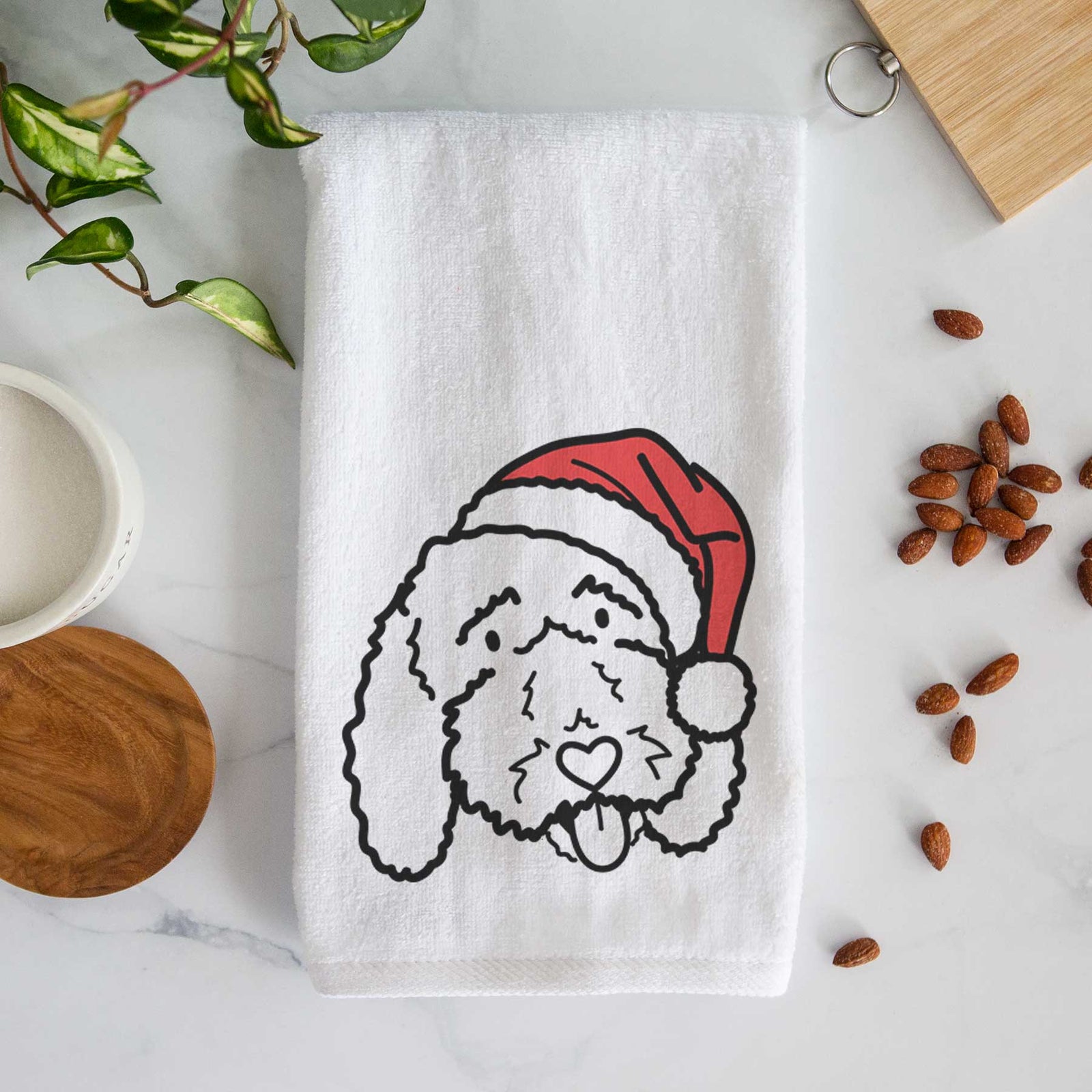 Minimalist line drawing of Ruby the Bernedoodle wearing a Santa hat on a decorative hand towel