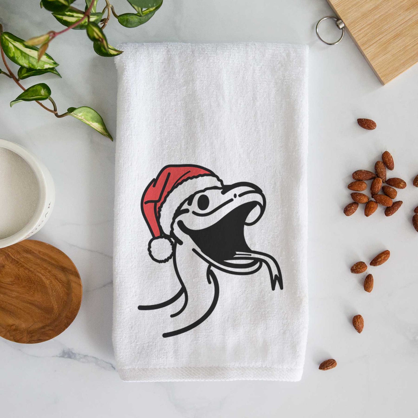 Minimalist line drawing of Spike the Snake wearing a Santa hat on a decorative hand towel