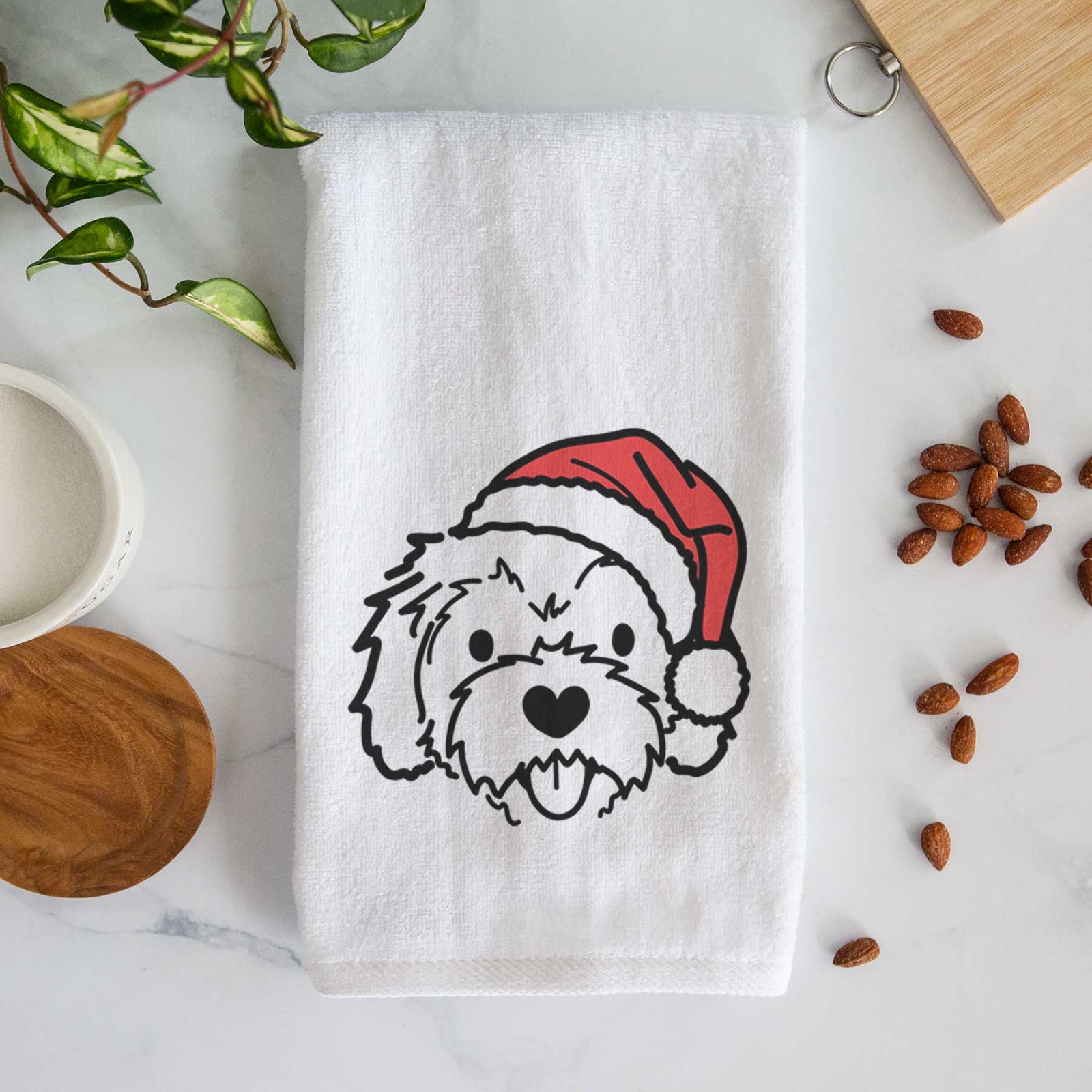 Minimalist line drawing of Sprinkles the Cockapoo wearing a Santa hat on a decorative hand towel