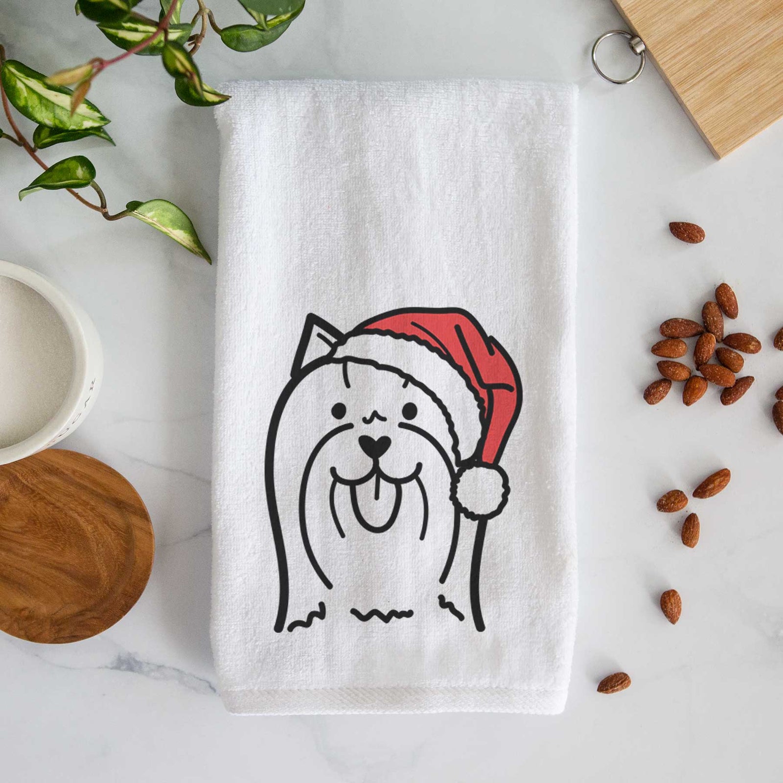 Minimalist line drawing of a Yorkshire Terrier wearing a Santa hat on a decorative hand towel