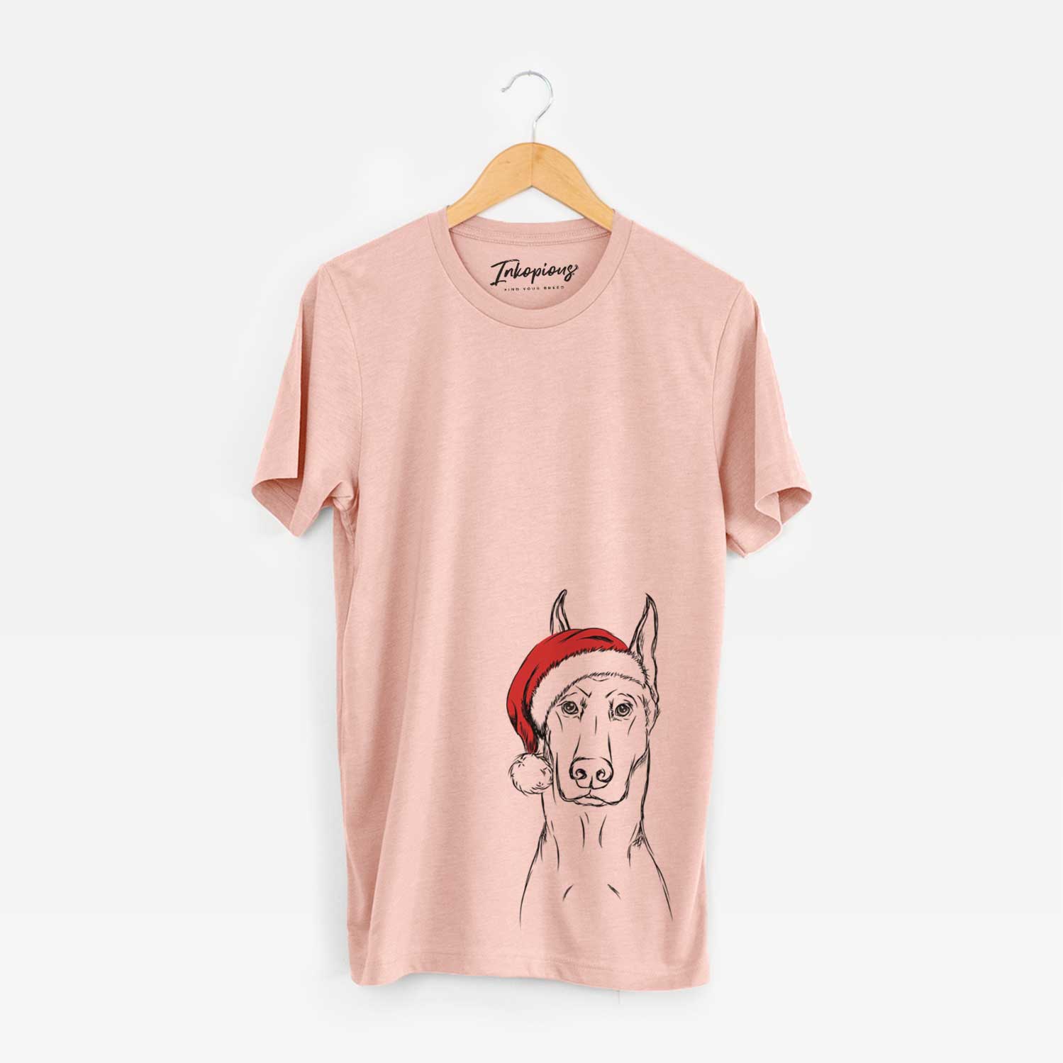 Hand-drawn sketch of Ace the Doberman Pinscher wearing a Santa hat on a Peach Unisex crewneck