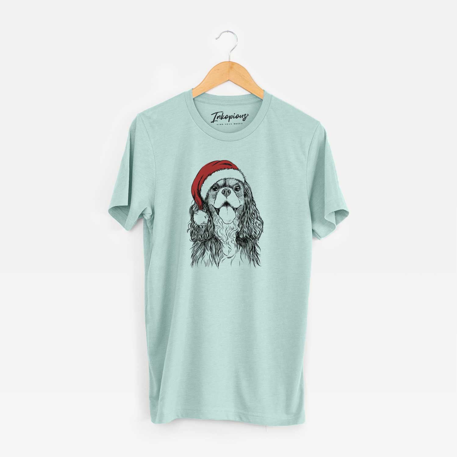 Hand-drawn sketch of Brandy the Cavalier King Charles Spaniel wearing a Santa hat on a Heather Sage Unisex crewneck