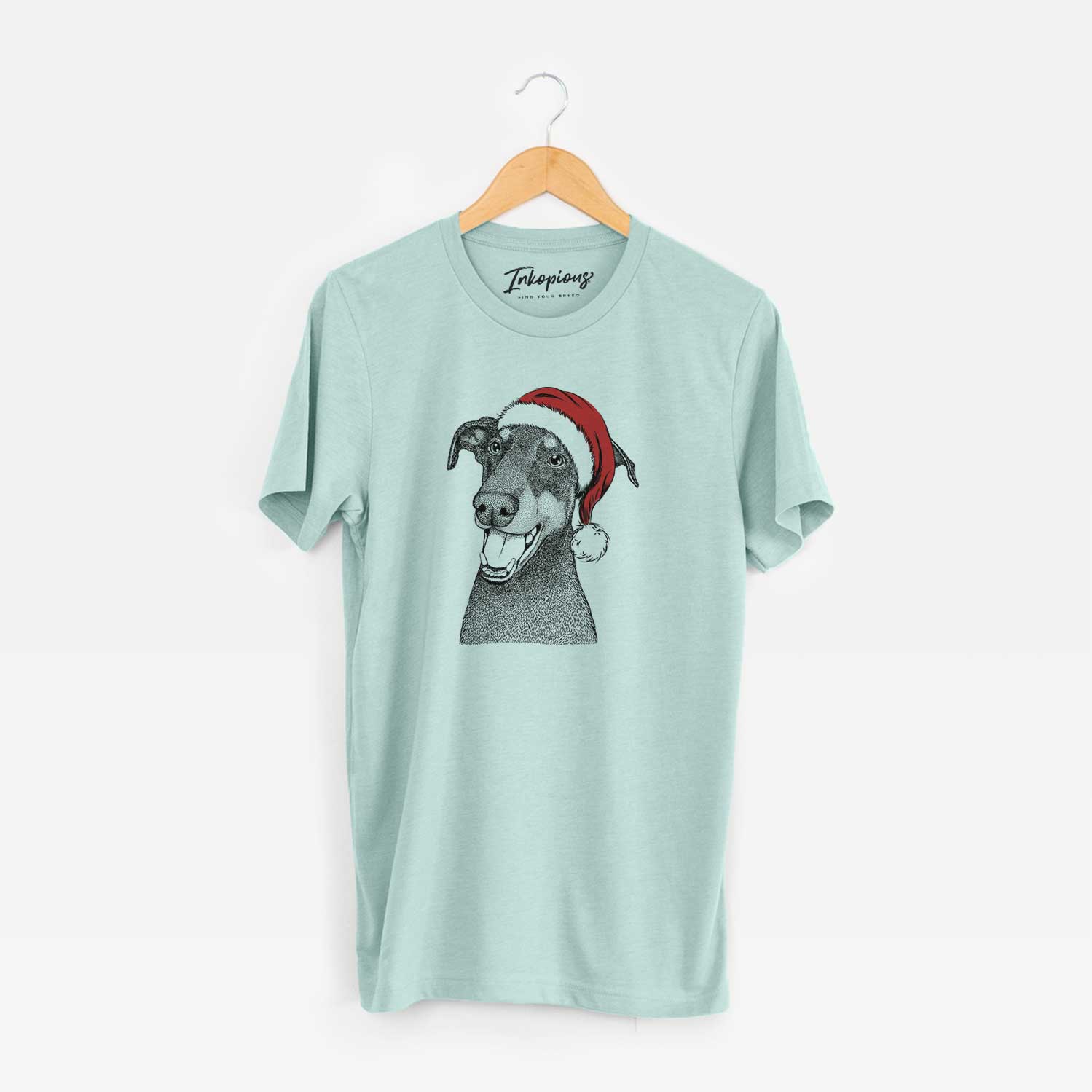 Hand-drawn sketch of Bunnie the Doberman Pinscher wearing a Santa hat on a Heather Sage Unisex crewneck