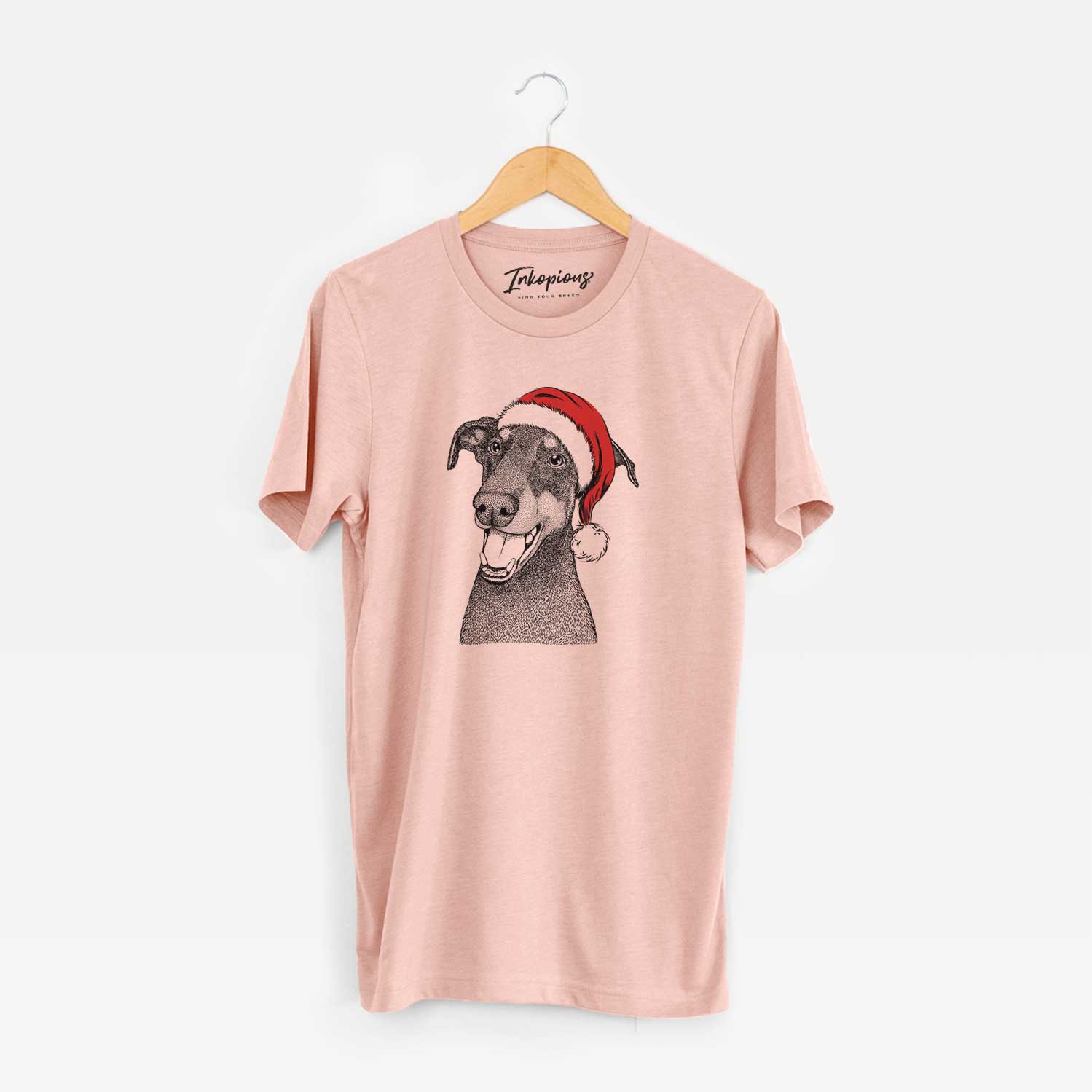 Hand-drawn sketch of Bunnie the Doberman Pinscher wearing a Santa hat on a Peach Unisex crewneck