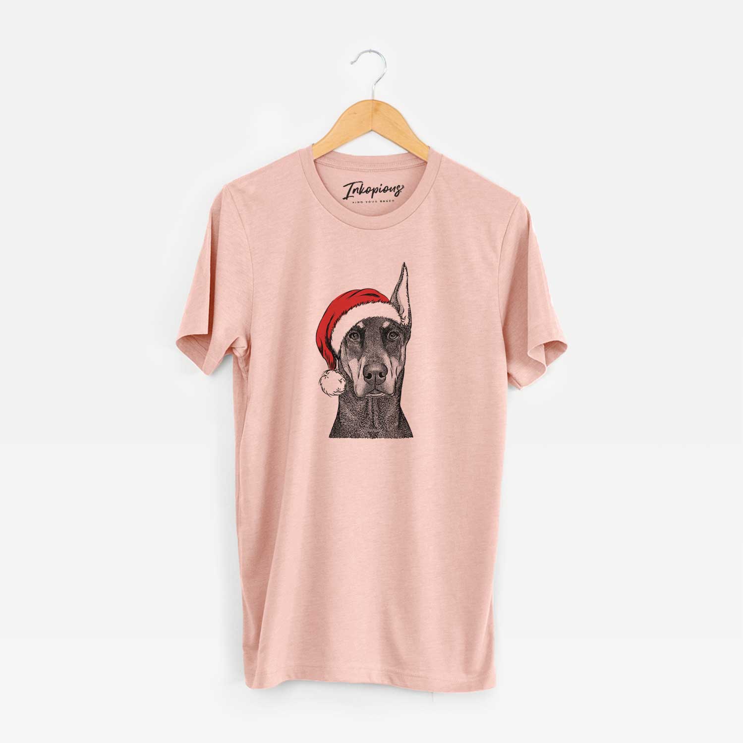 Hand-drawn sketch of Drake the Doberman Pinscher wearing a Santa hat on a Peach Unisex crewneck