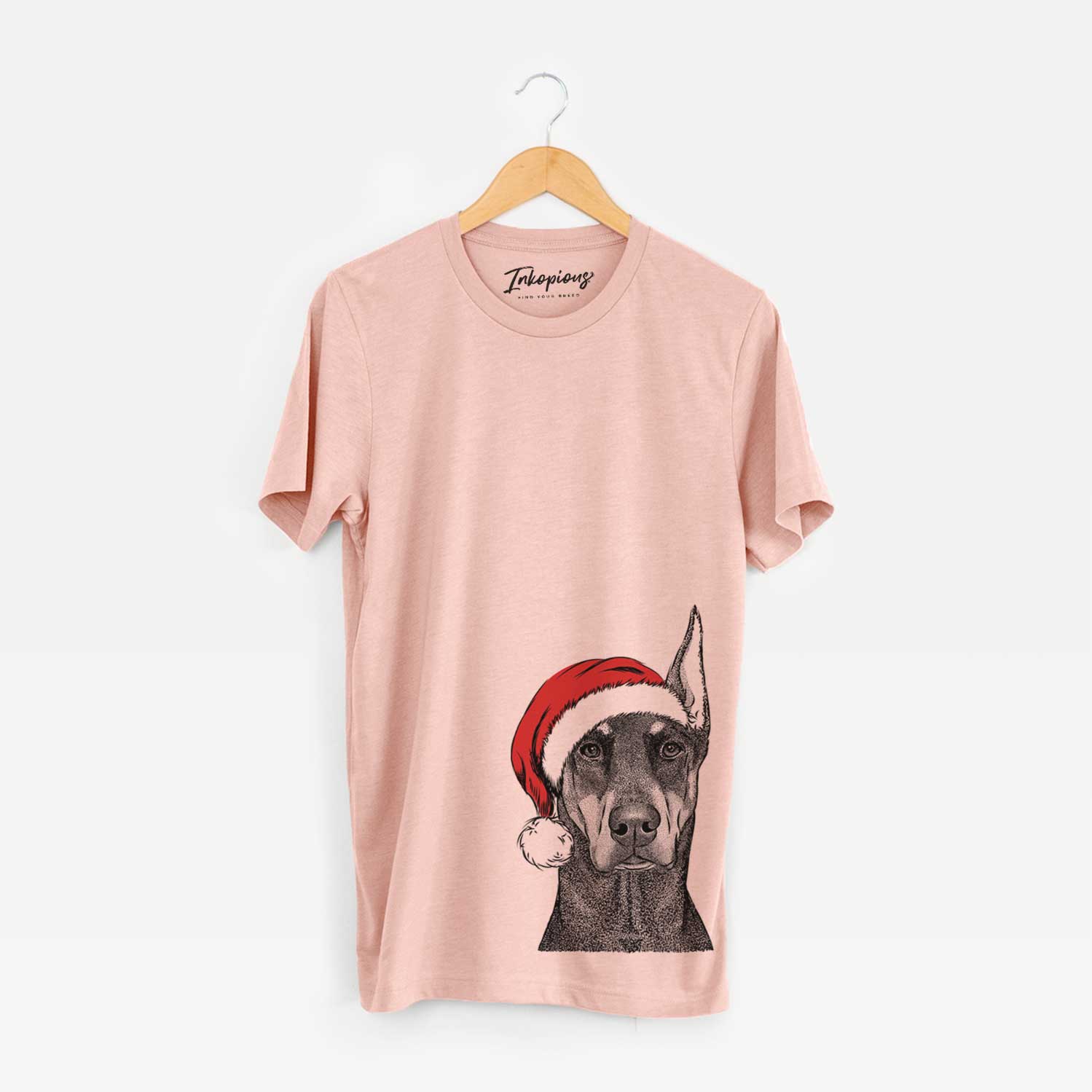 Hand-drawn sketch of Drake the Doberman Pinscher wearing a Santa hat on a Peach Unisex crewneck