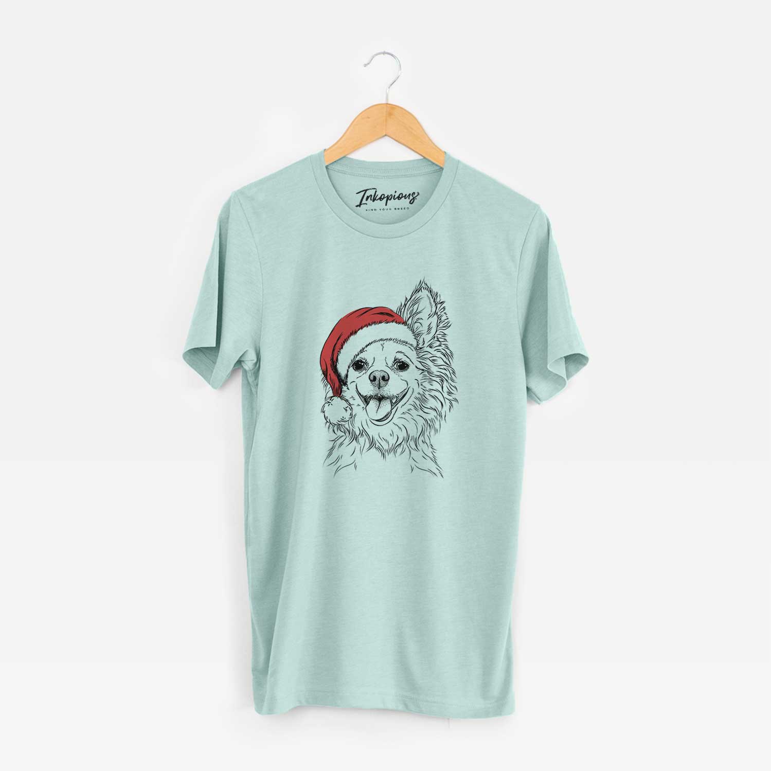 Hand-drawn sketch of Jasper the Pomchi wearing a Santa hat on a Heather Sage Unisex crewneck