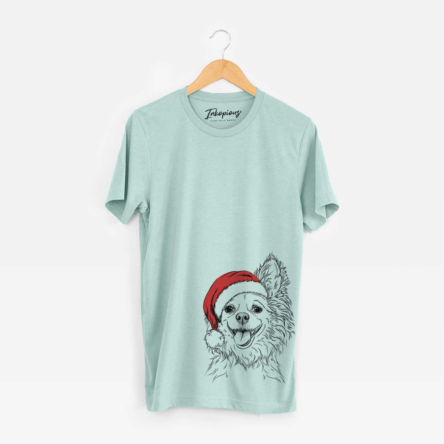 Hand-drawn sketch of Jasper the Pomchi wearing a Santa hat on a Heather Sage Unisex crewneck