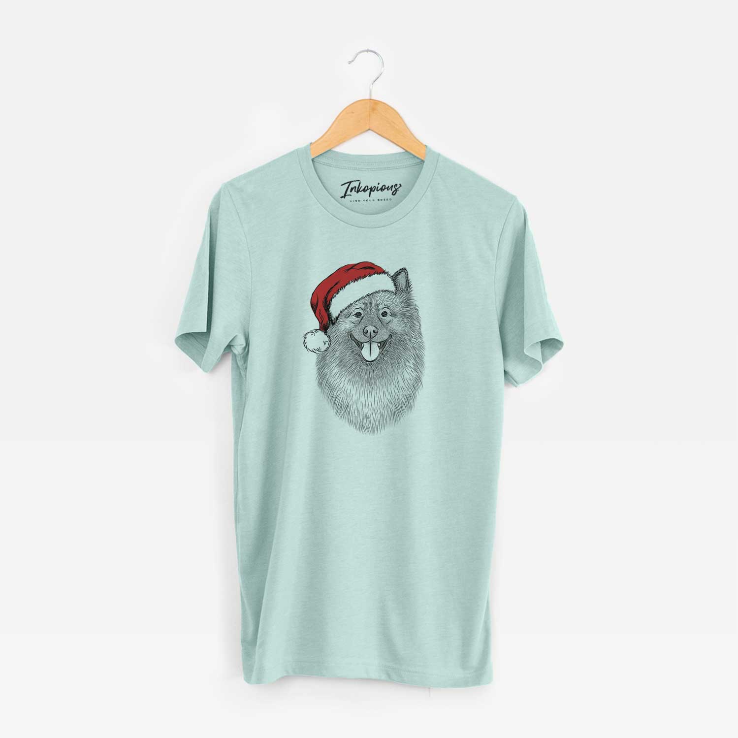 Hand-drawn sketch of Kai the Keeshond wearing a Santa hat on a Heather Sage Unisex crewneck