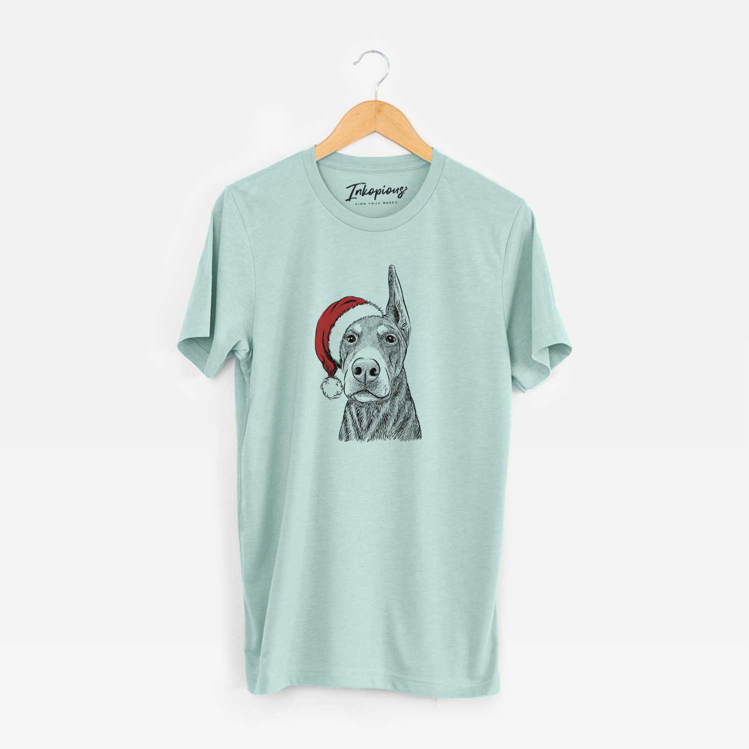 Hand-drawn sketch of Luna the Doberman Pinscher wearing a Santa hat on a Heather Sage Unisex crewneck