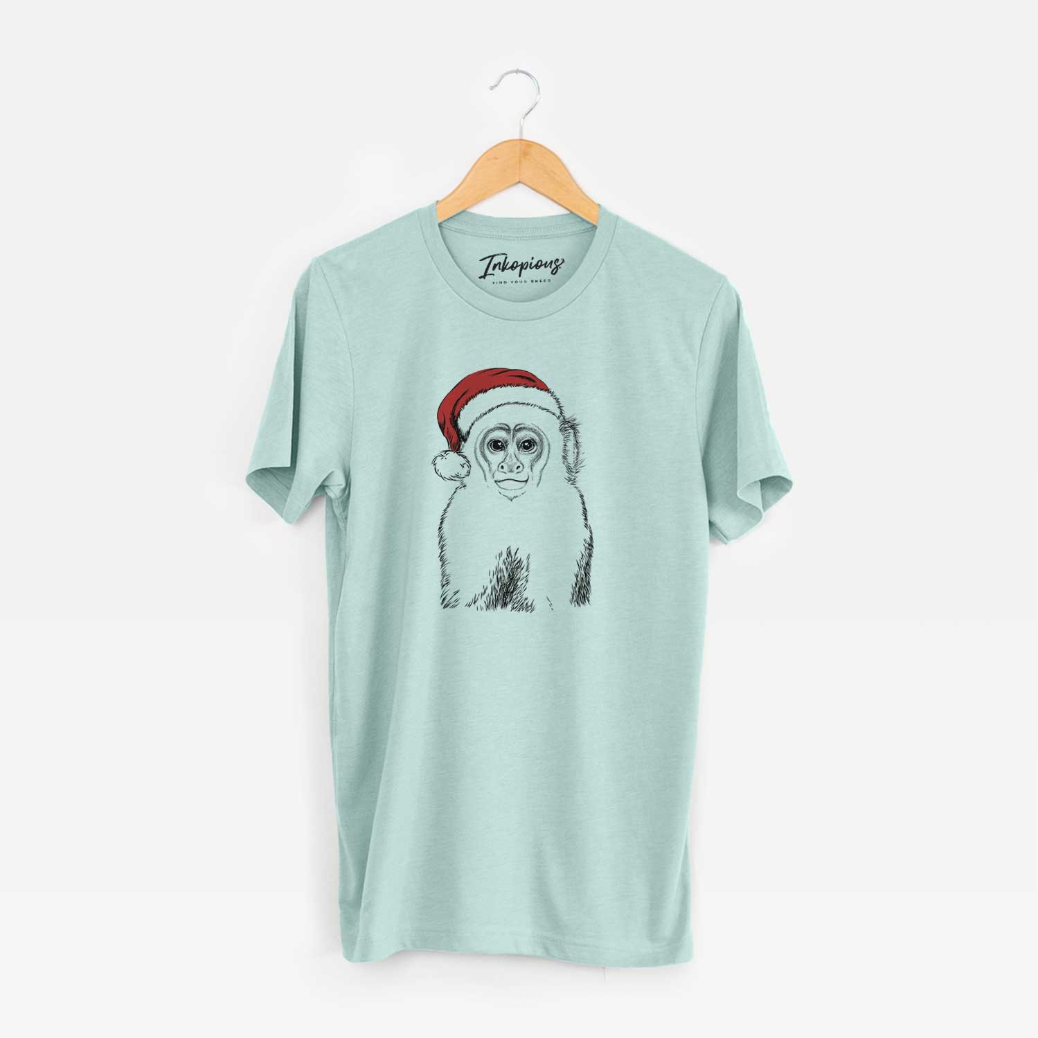 Hand-drawn sketch of Marcel the Capuchin Monkey wearing a Santa hat on a Heather Sage Unisex crewneck