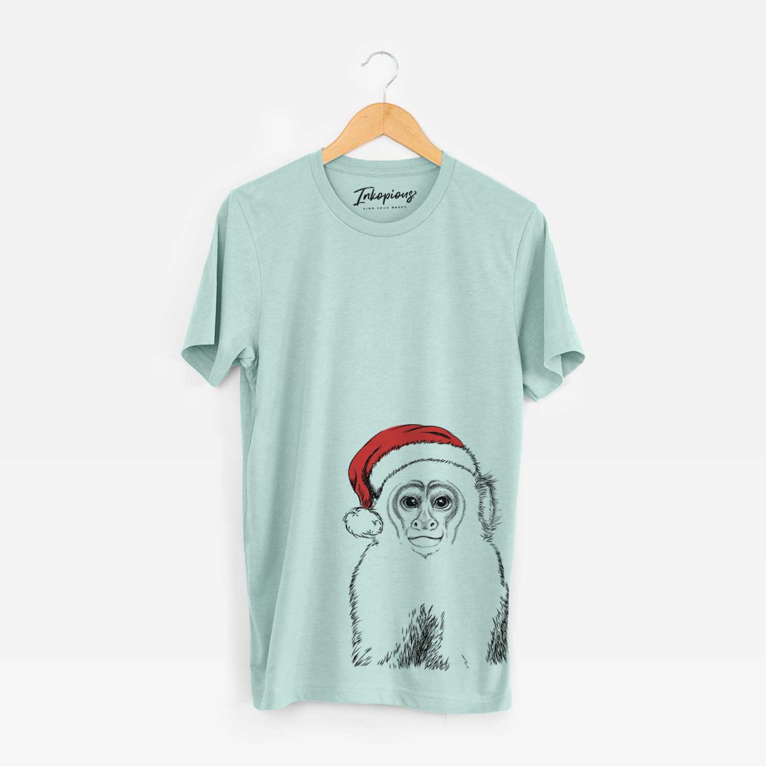 Hand-drawn sketch of Marcel the Capuchin Monkey wearing a Santa hat on a Heather Sage Unisex crewneck