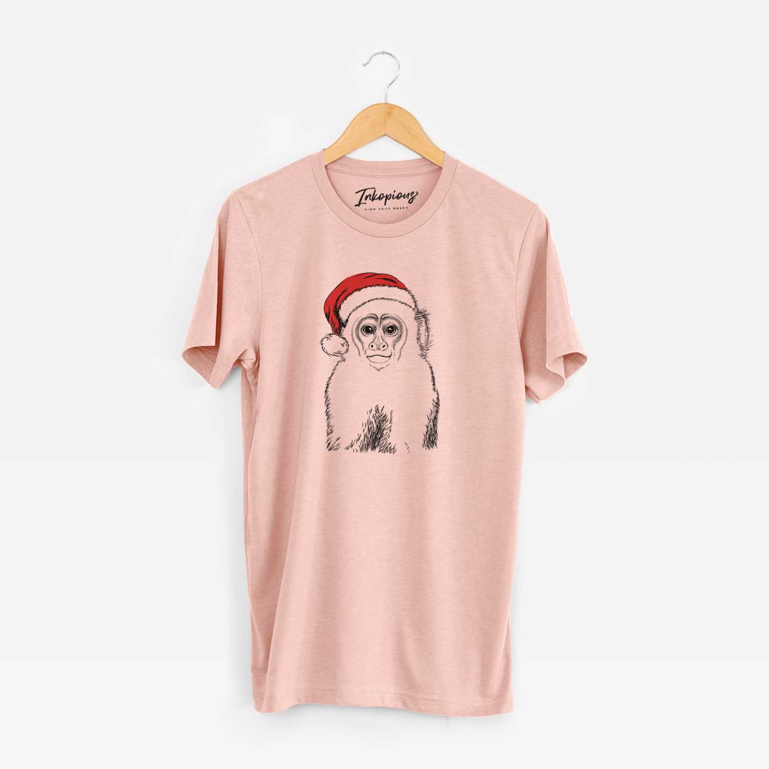 Hand-drawn sketch of Marcel the Capuchin Monkey wearing a Santa hat on a Peach Unisex crewneck