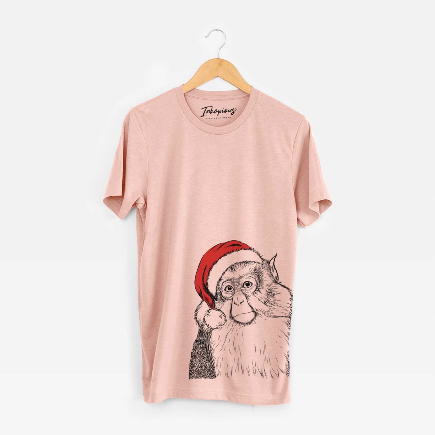 Hand-drawn sketch of Matata the Mona Monkey wearing a Santa hat on a Peach Unisex crewneck