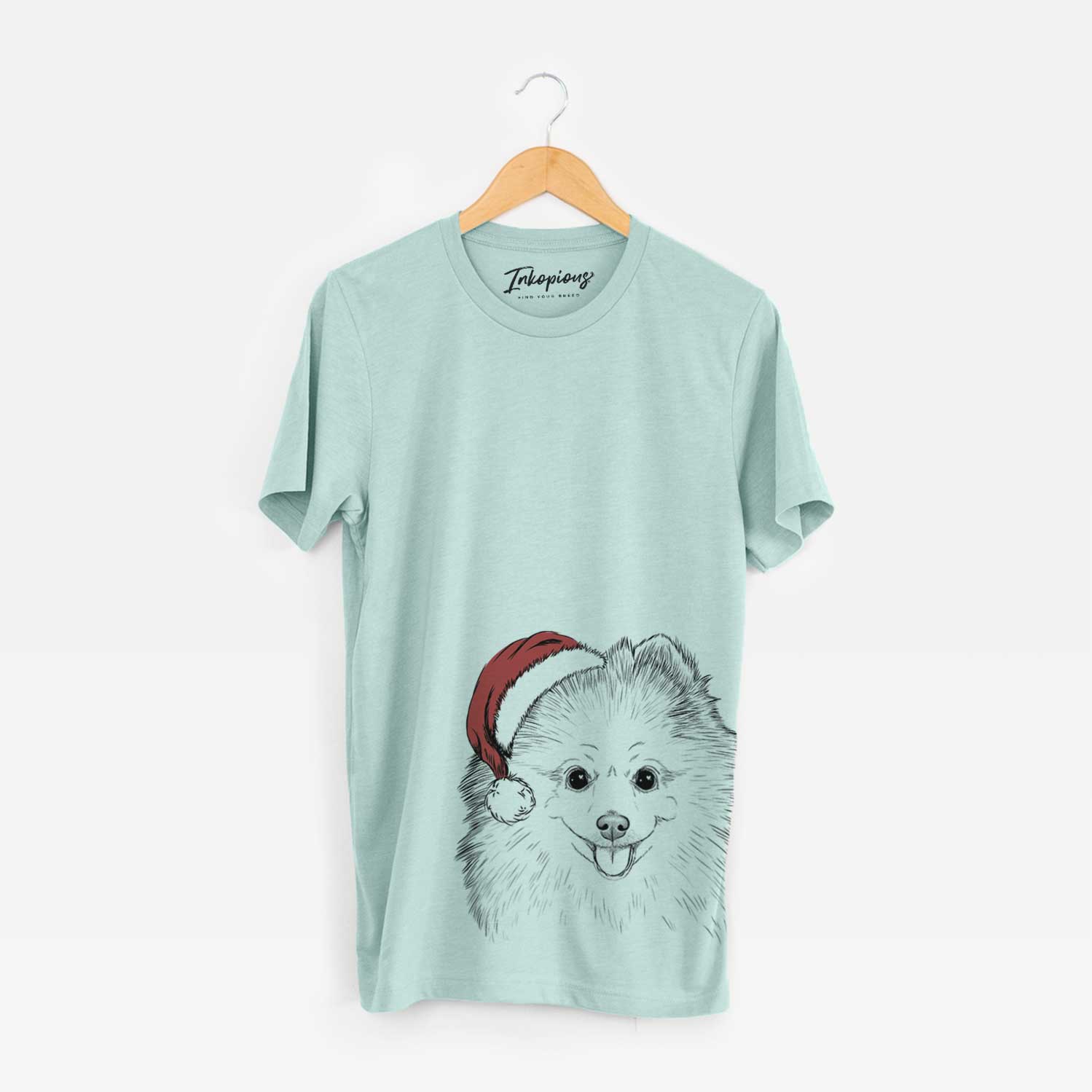 Hand-drawn sketch of Piper Jo the Pomeranian wearing a Santa hat on a Heather Sage Unisex crewneck