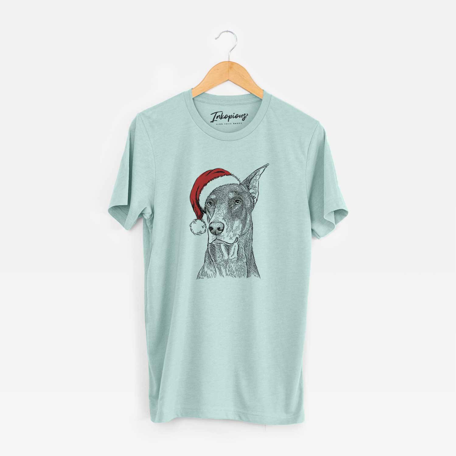 Hand-drawn sketch of RJ the Doberman Pinscher wearing a Santa hat on a Heather Sage Unisex crewneck