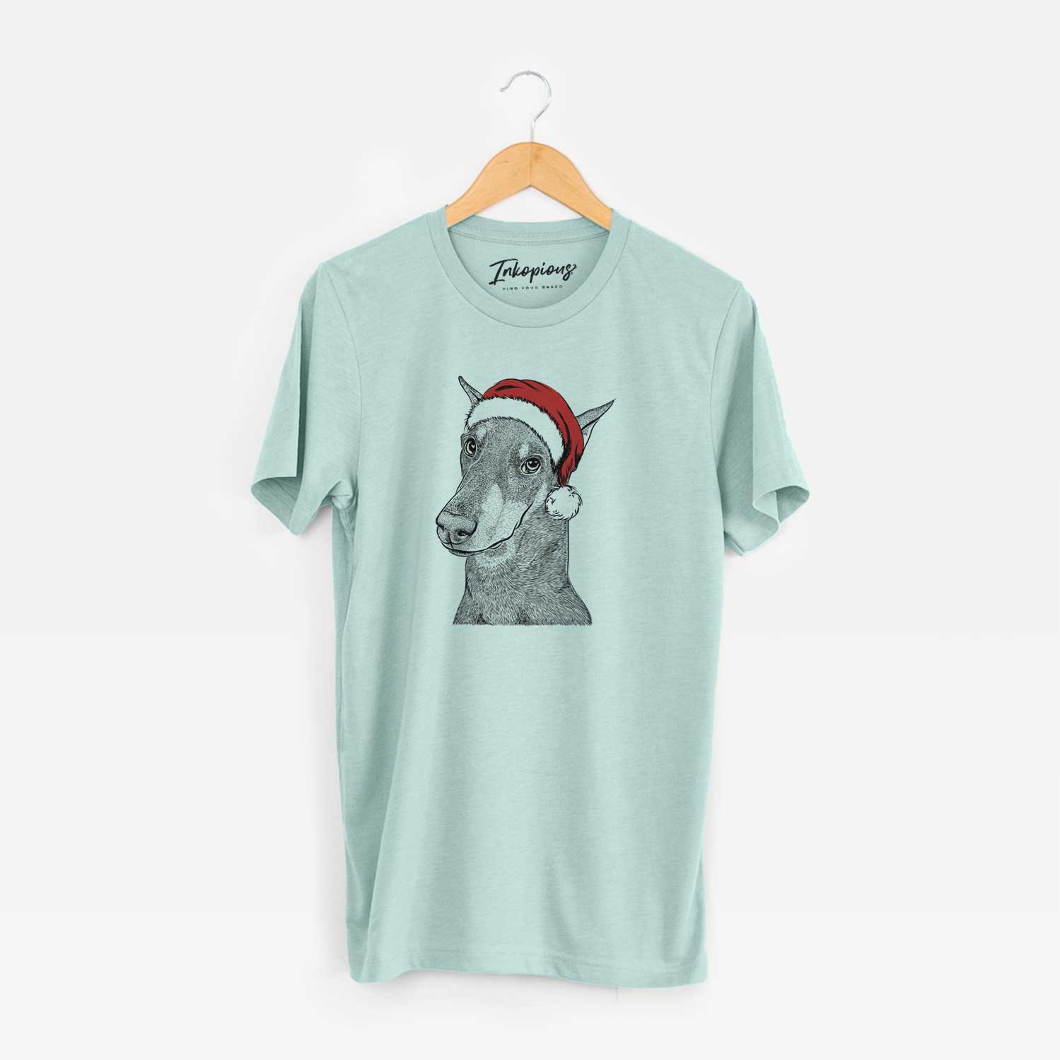 Hand-drawn sketch of Shelby the Doberman Pinscher wearing a Santa hat on a Heather Sage Unisex crewneck