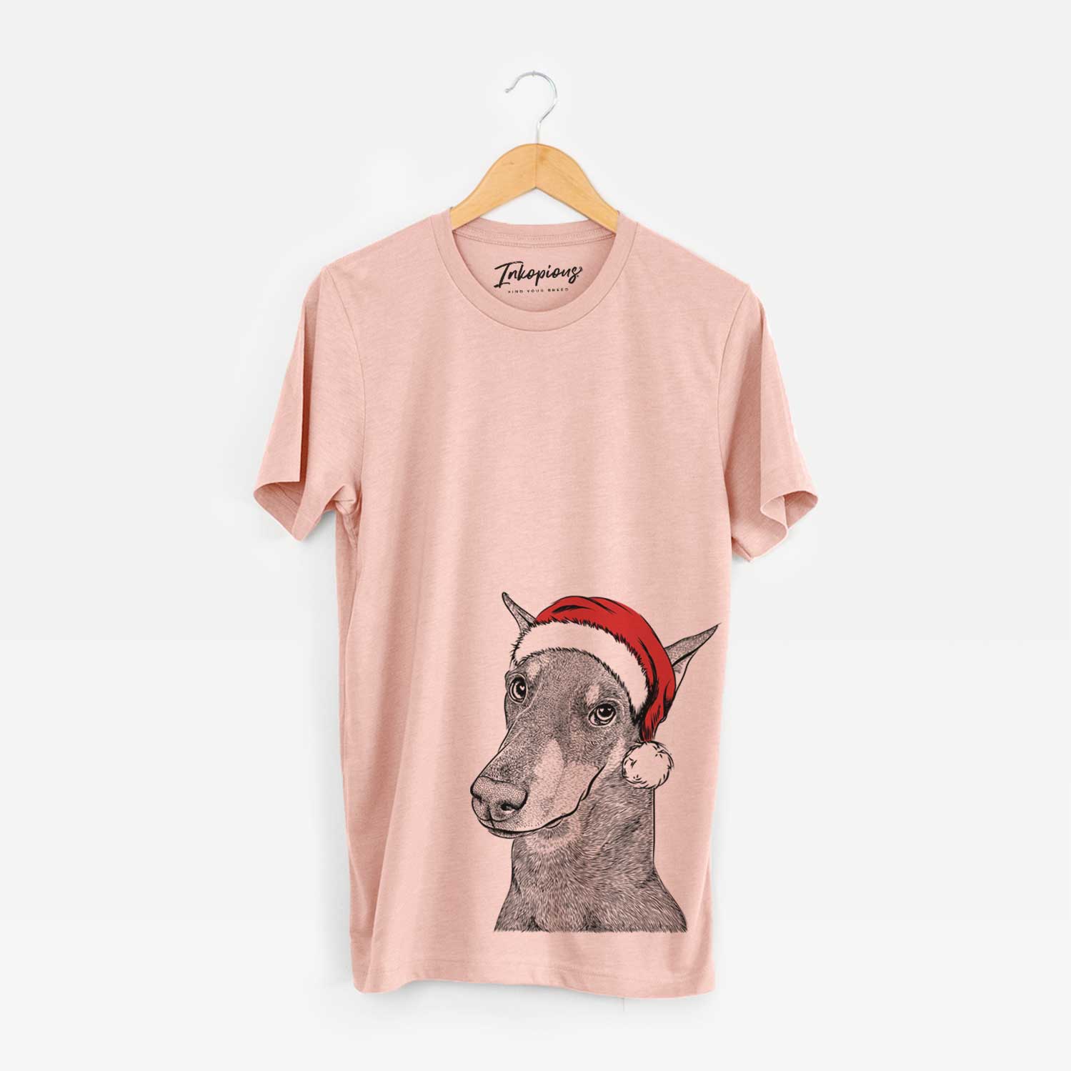 Hand-drawn sketch of Shelby the Doberman Pinscher wearing a Santa hat on a Peach Unisex crewneck