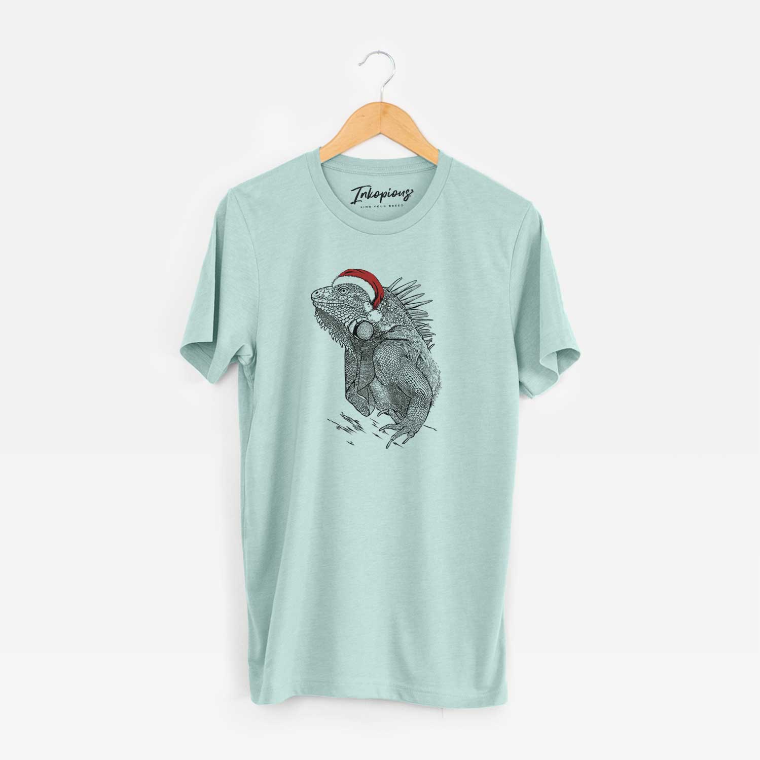 Hand-drawn sketch of Spike the Iguana wearing a Santa hat on a Heather Sage Unisex crewneck