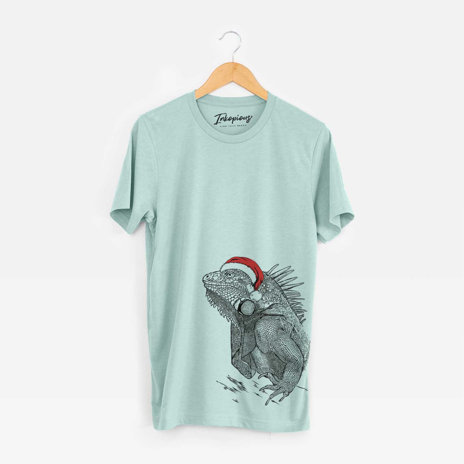 Hand-drawn sketch of Spike the Iguana wearing a Santa hat on a Heather Sage Unisex crewneck