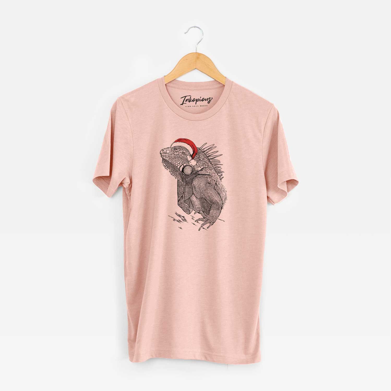 Hand-drawn sketch of Spike the Iguana wearing a Santa hat on a Peach Unisex crewneck