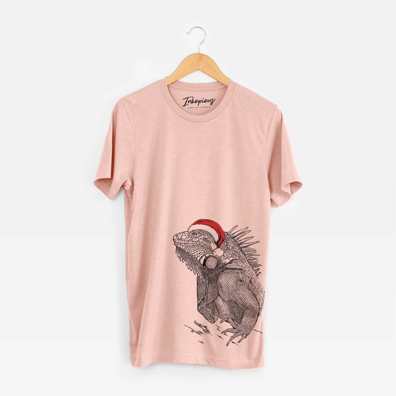 Hand-drawn sketch of Spike the Iguana wearing a Santa hat on a Peach Unisex crewneck