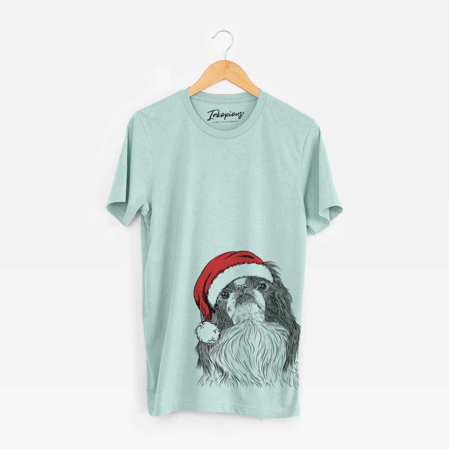 Hand-drawn sketch of Suki the Japanese Chin wearing a Santa hat on a Heather Sage Unisex crewneck