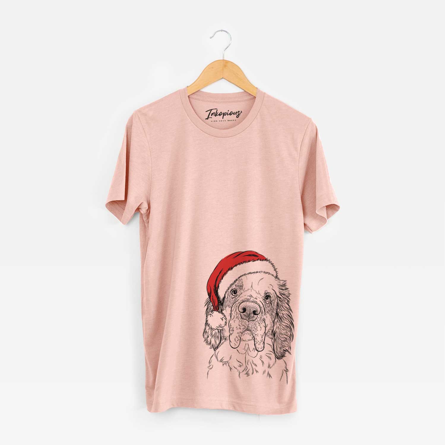 Hand-drawn sketch of Sully the Clumber Spaniel wearing a Santa hat on a Peach Unisex crewneck