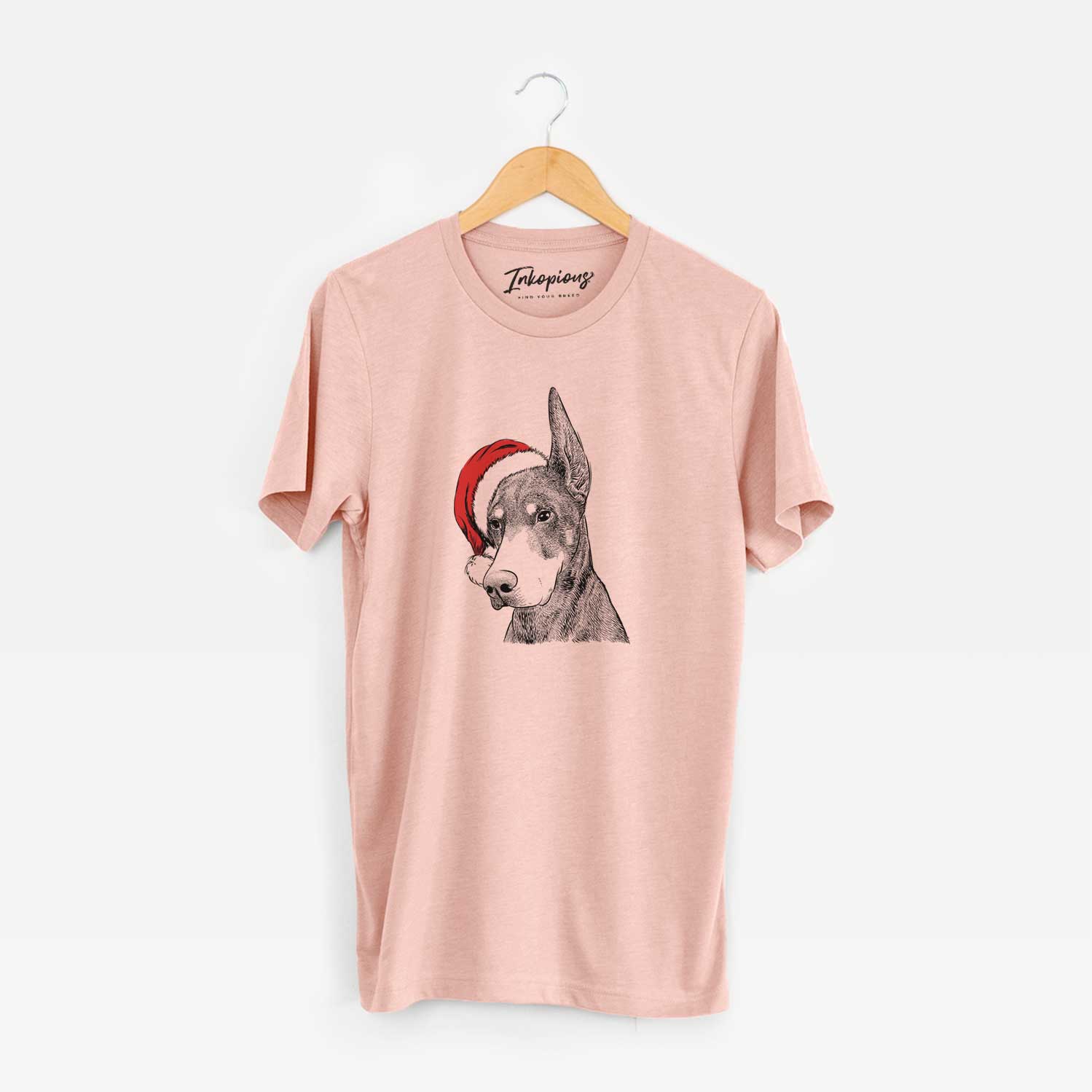 Hand-drawn sketch of Sunny the Doberman Pinscher wearing a Santa hat on a Peach Unisex crewneck