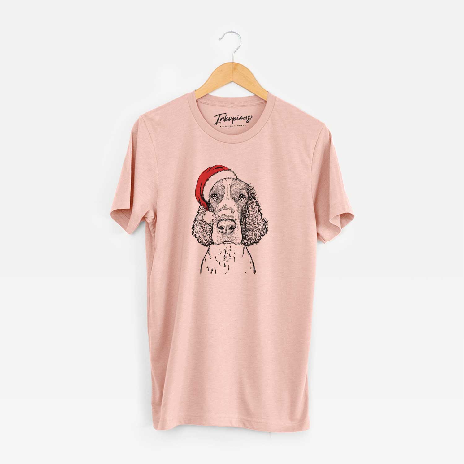 Hand-drawn sketch of Wilbur the English Springer Spaniel wearing a Santa hat on a Peach Unisex crewneck
