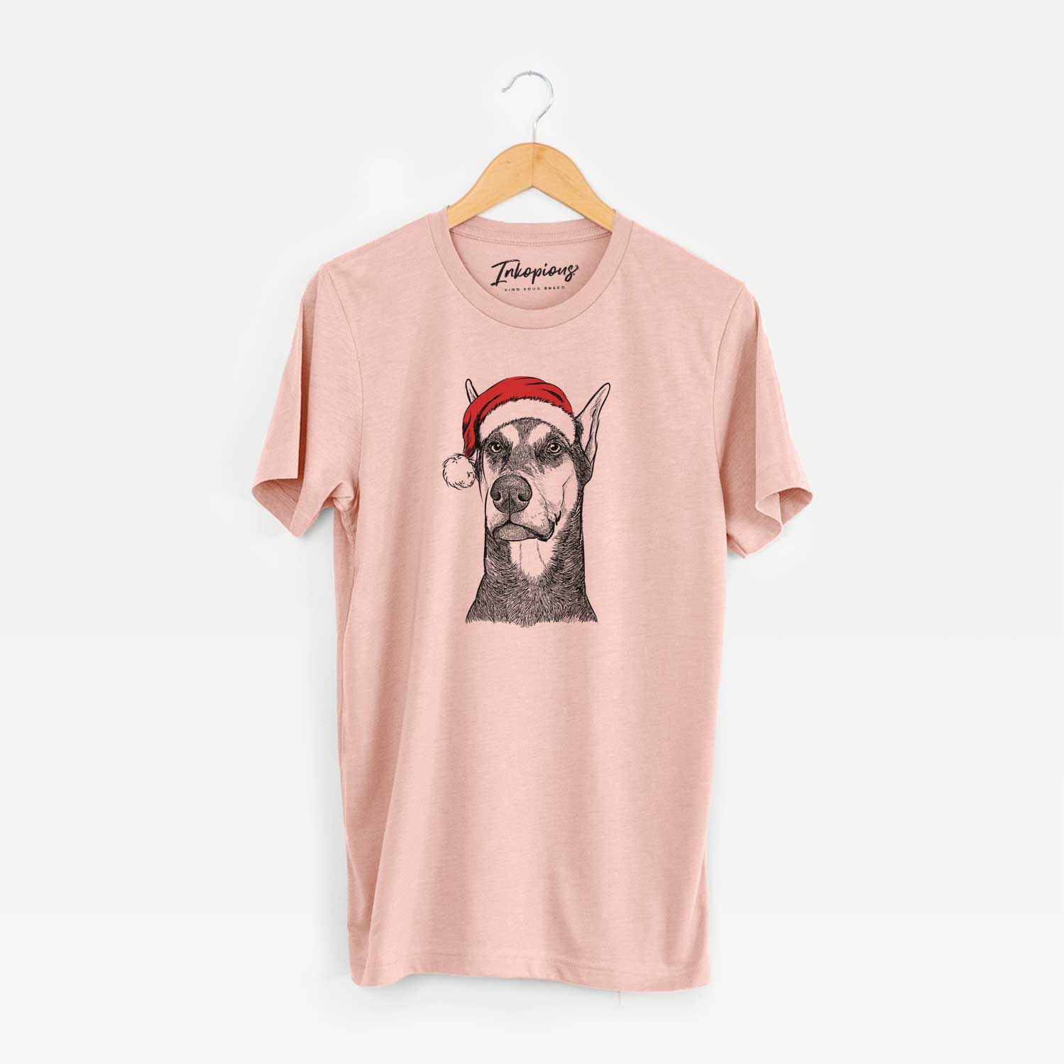Hand-drawn sketch of Zeus the Doberman Pinscher wearing a Santa hat on a Peach Unisex crewneck