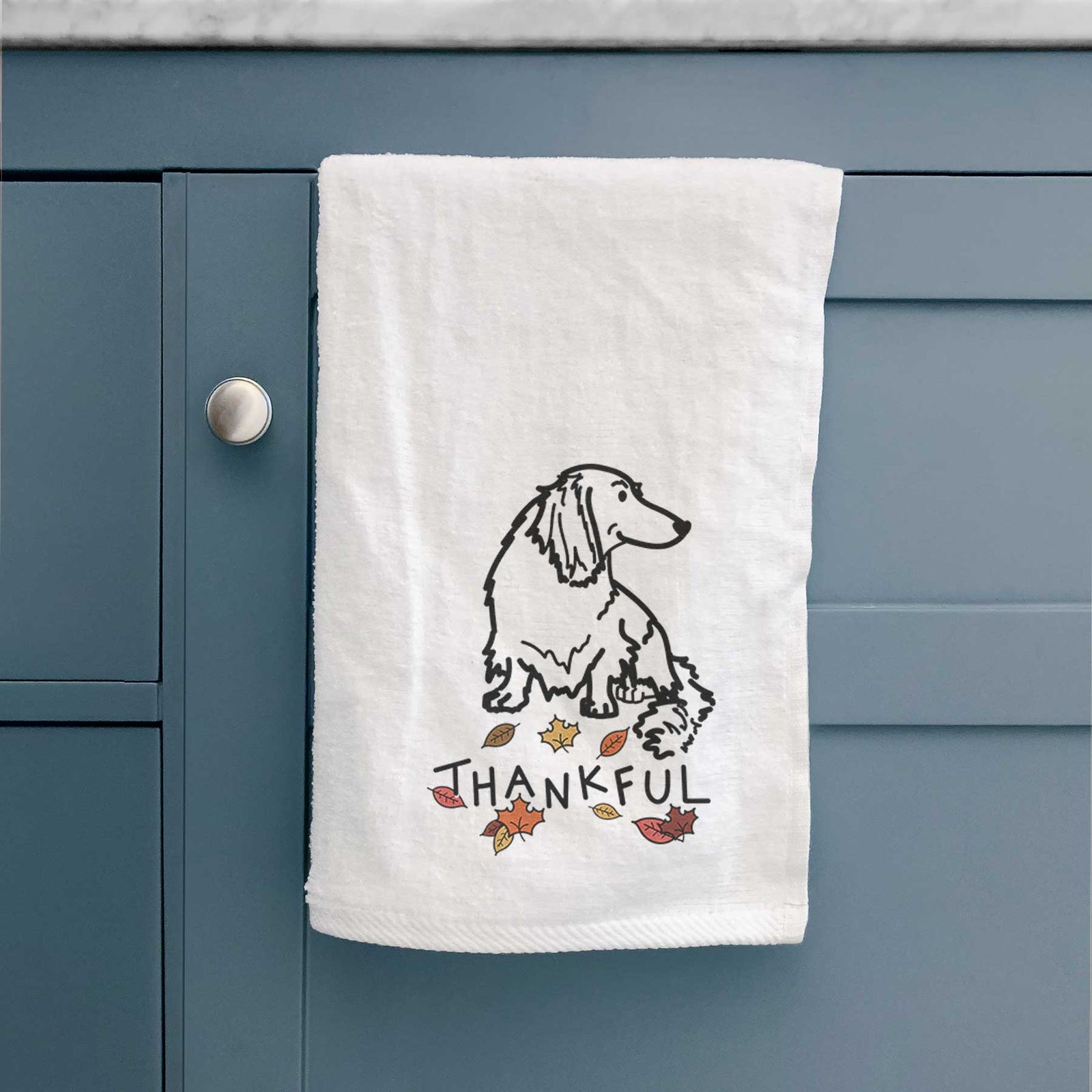 Minimalist line drawing of Bella the Dachshund with 'Thankful' lettering on a decorative hand towel