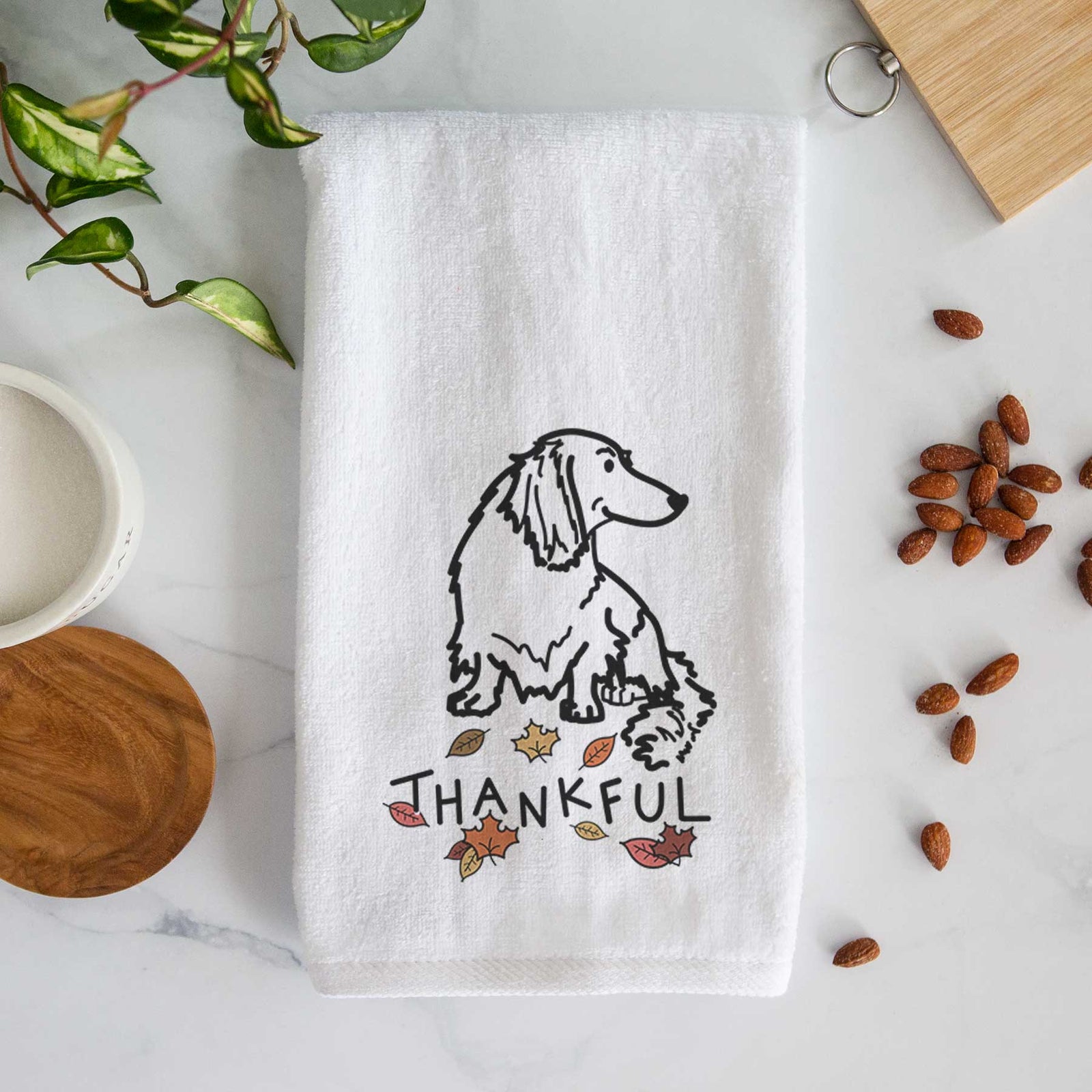 Minimalist line drawing of Bella the Dachshund with 'Thankful' lettering on a decorative hand towel