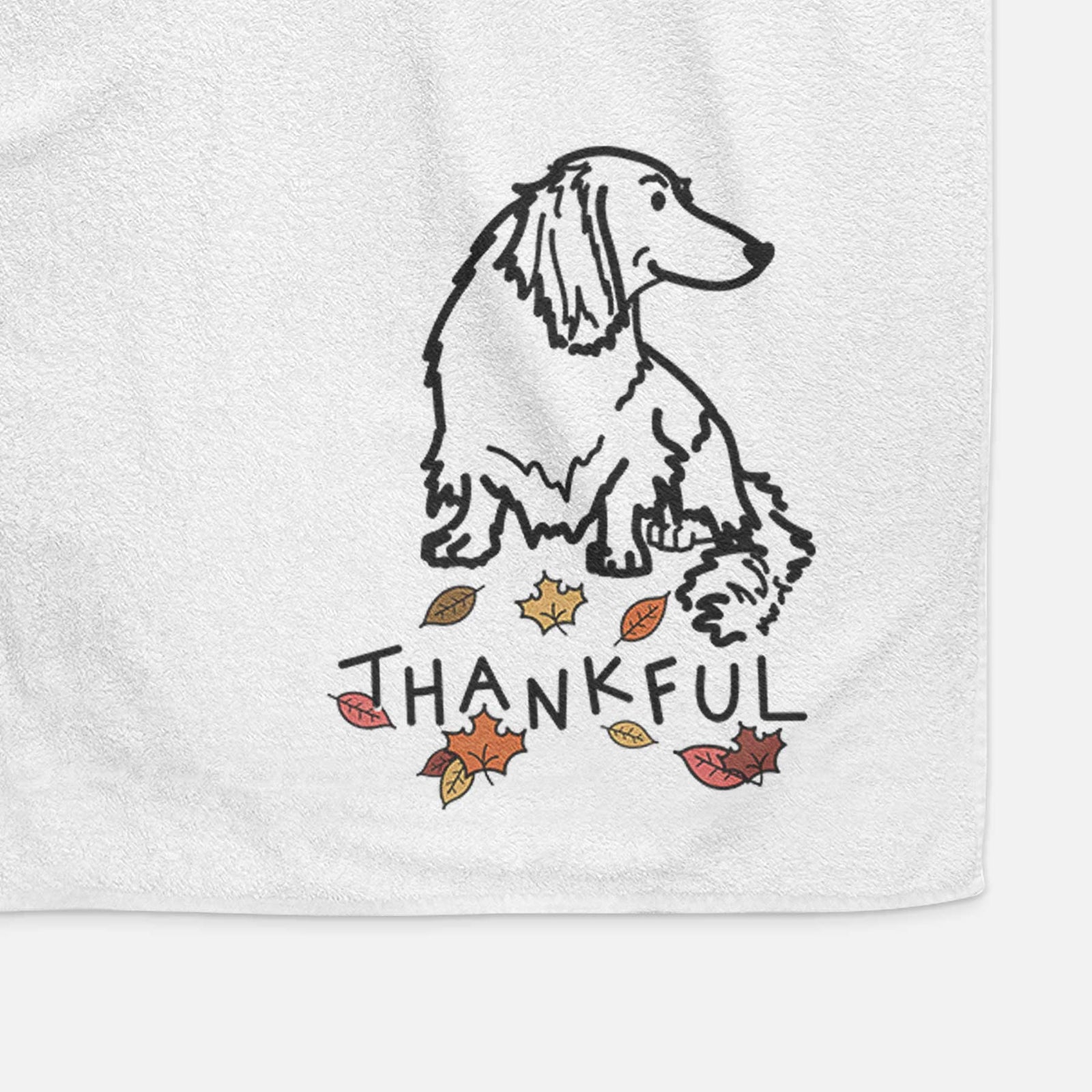Minimalist line drawing of Bella the Dachshund with 'Thankful' lettering on a decorative hand towel