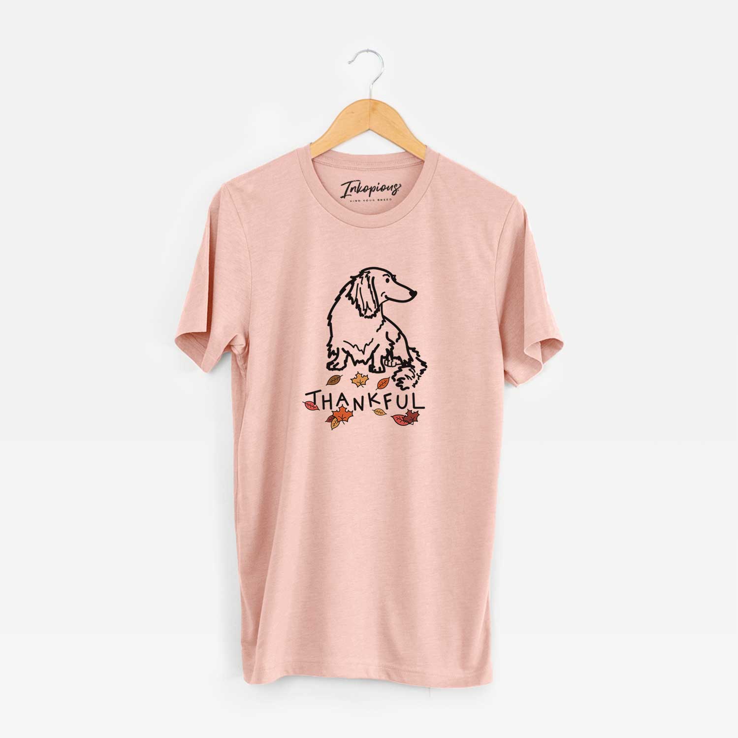 Minimalist line drawing of Bella the Dachshund with 'Thankful' lettering on a Peach Unisex crewneck