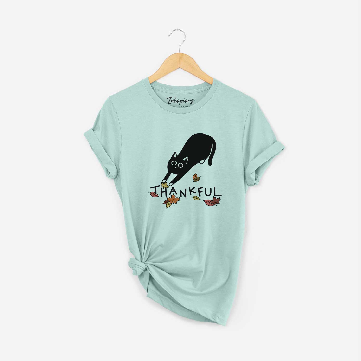 Minimalist line drawing of Bug the Black Cat with 'Thankful' lettering on a Heather Sage Unisex crewneck