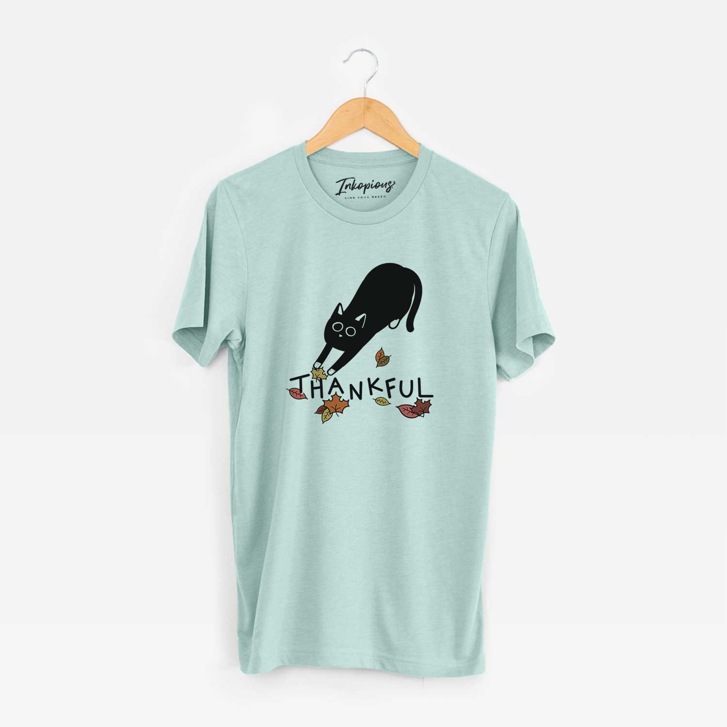 Minimalist line drawing of Bug the Black Cat with 'Thankful' lettering on a Heather Sage Unisex crewneck