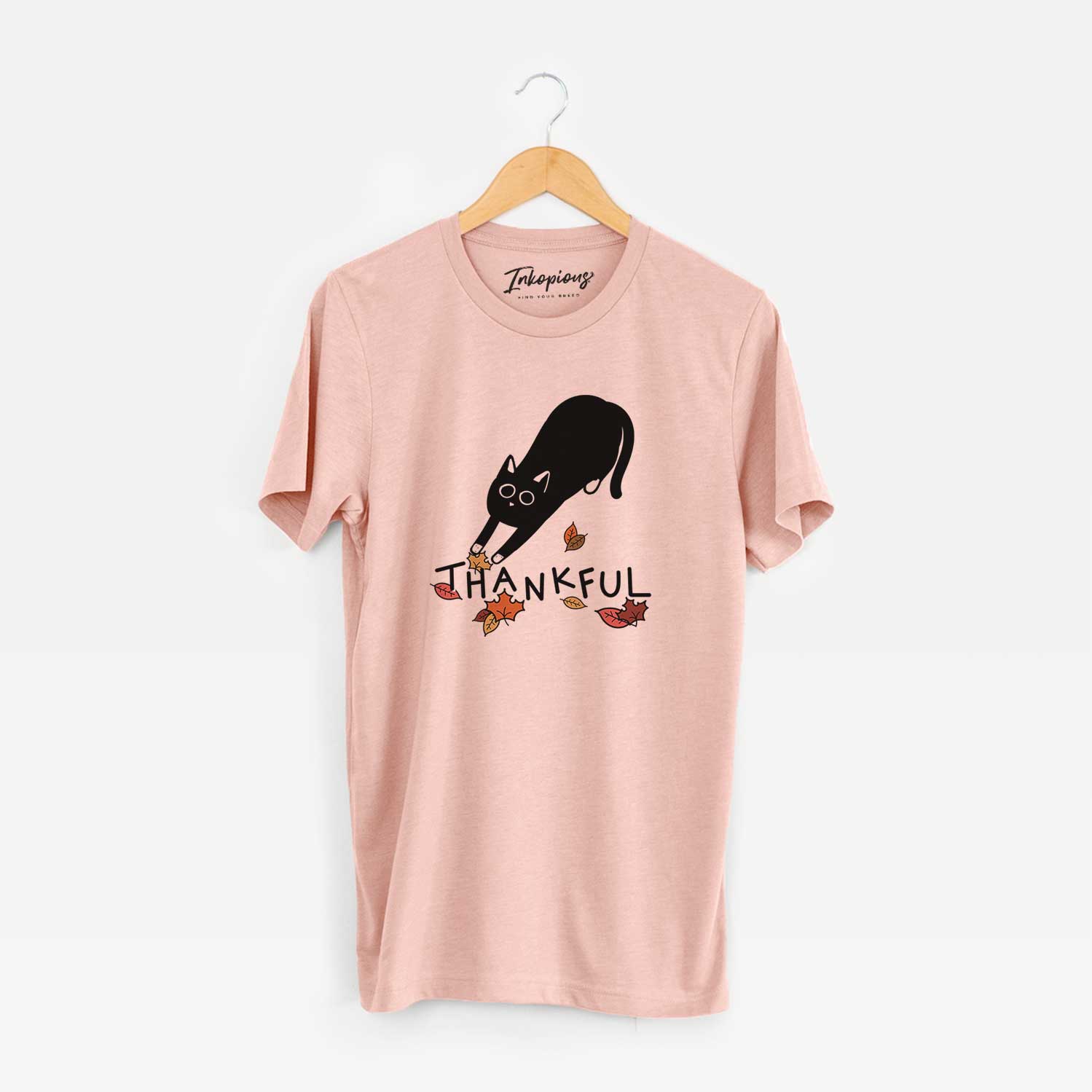 Minimalist line drawing of Bug the Black Cat with 'Thankful' lettering on a Peach Unisex crewneck