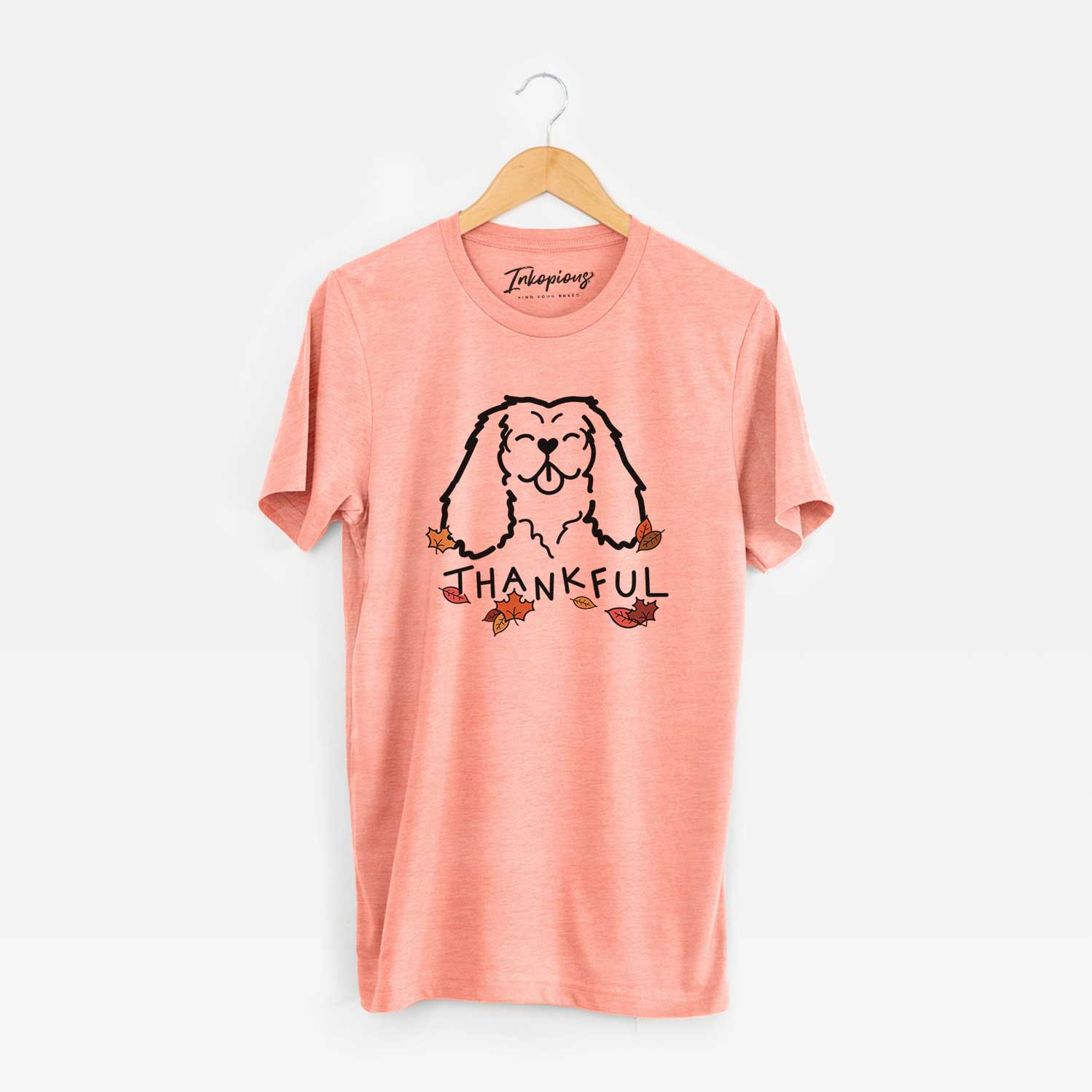 Minimalist line drawing of a Cavalier King Charles Spaniel with 'Thankful' lettering on a Sunset Unisex crewneck