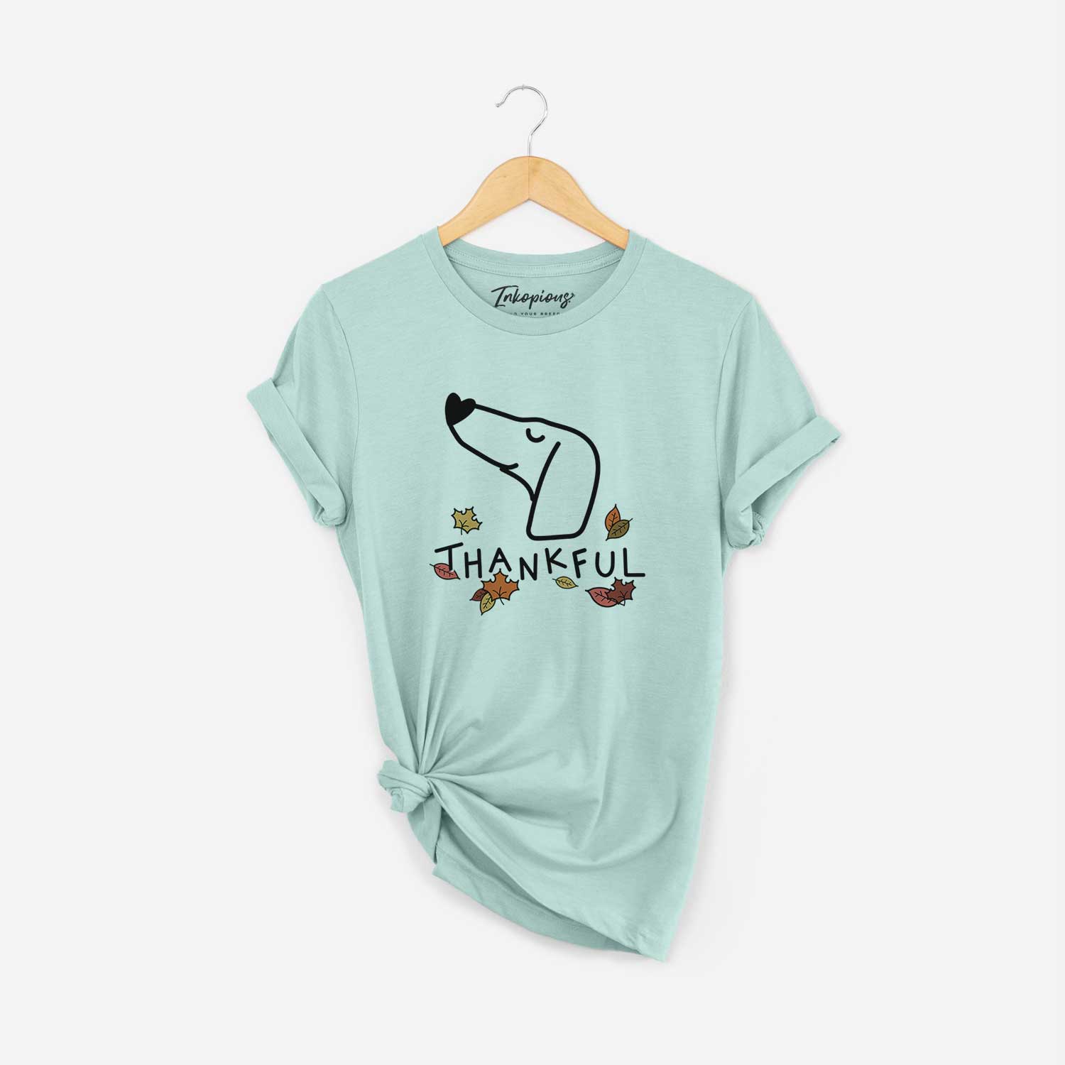 Minimalist line drawing of a Dachshund with 'Thankful' lettering on a Heather Sage Unisex crewneck