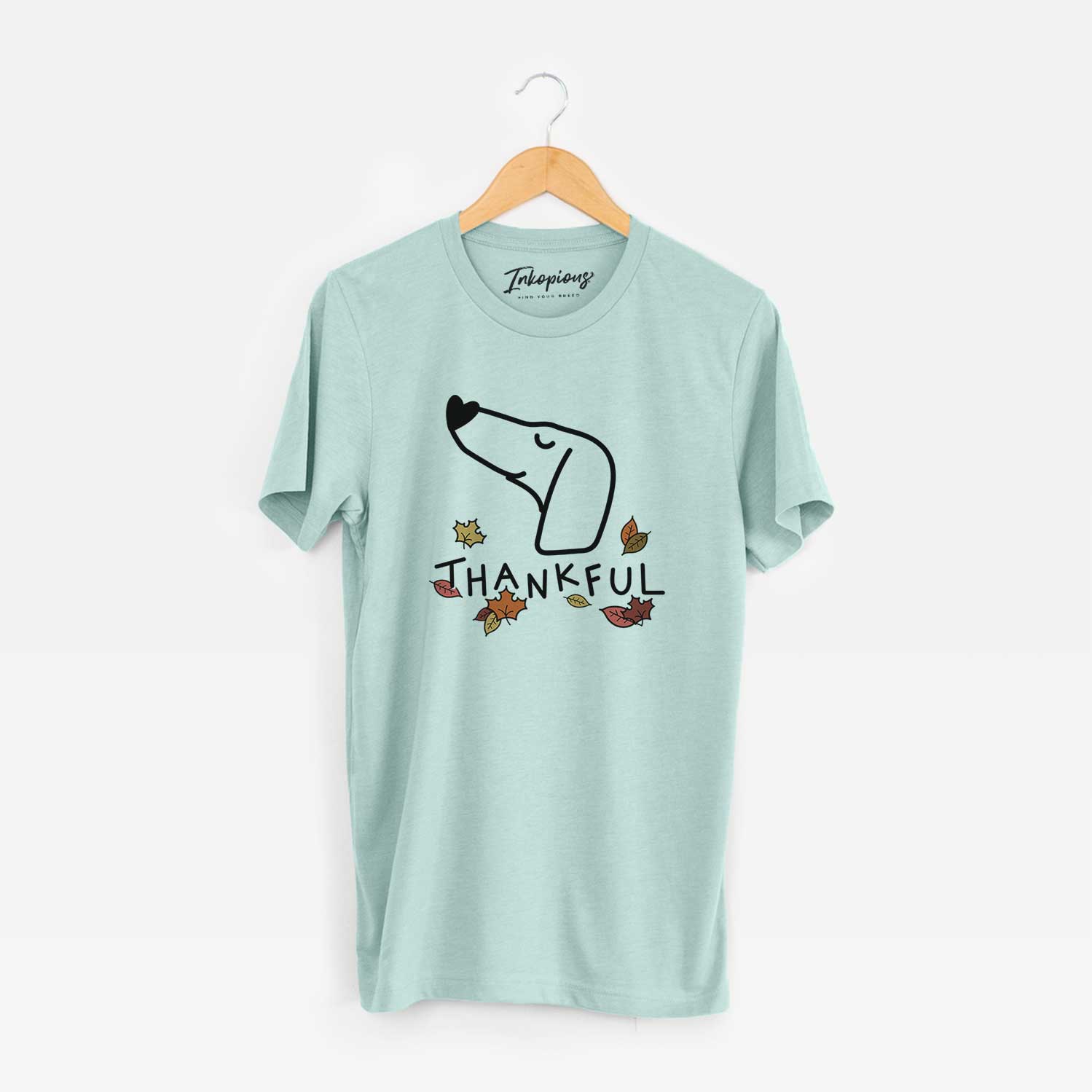 Minimalist line drawing of a Dachshund with 'Thankful' lettering on a Heather Sage Unisex crewneck