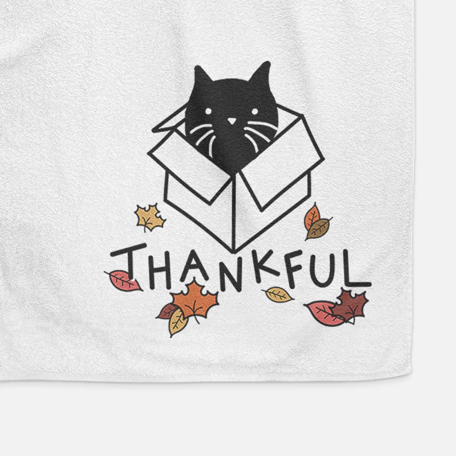 Minimalist line drawing of Doc the Black Cat in a Box with 'Thankful' lettering on a decorative hand towel