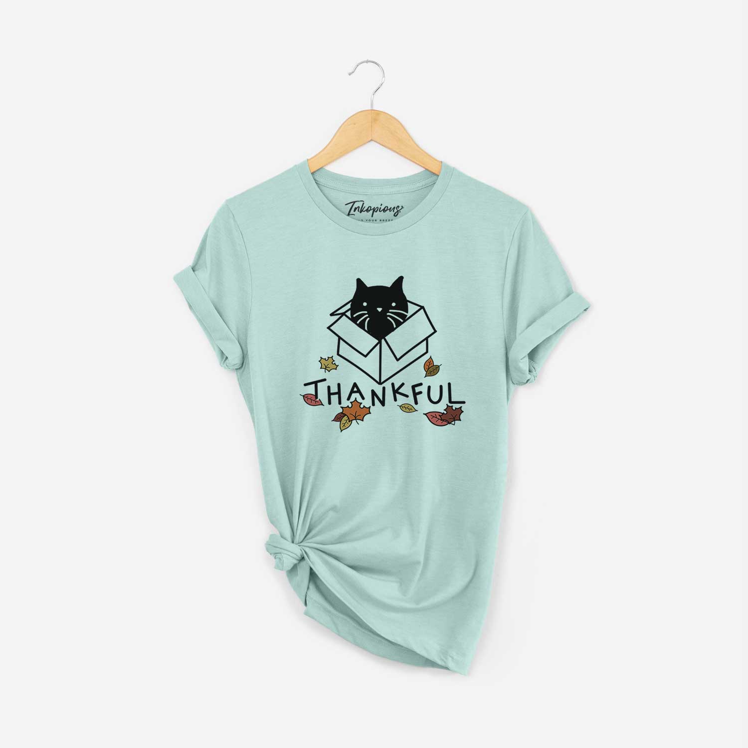 Minimalist line drawing of Doc the Black Cat in a Box with 'Thankful' lettering on a Heather Sage Unisex crewneck