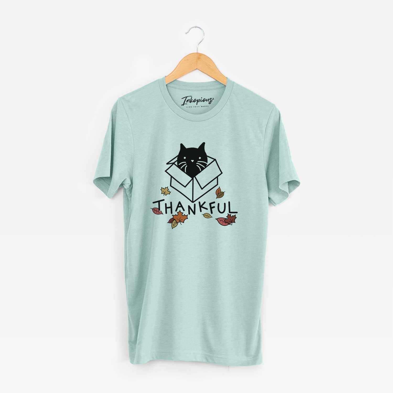 Minimalist line drawing of Doc the Black Cat in a Box with 'Thankful' lettering on a Heather Sage Unisex crewneck