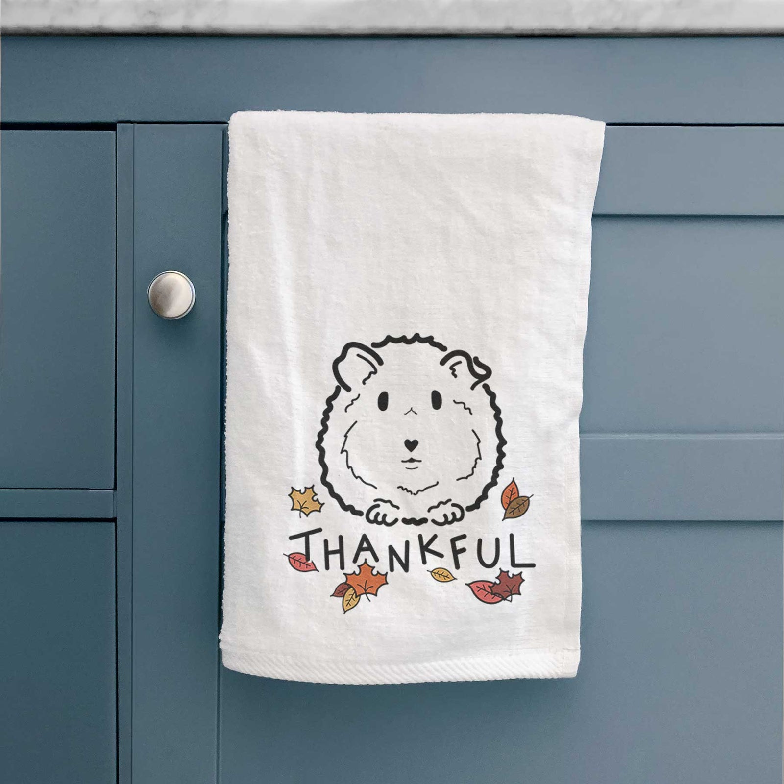 Minimalist line drawing of Duke the Guinea Pig with 'Thankful' lettering on a decorative hand towel