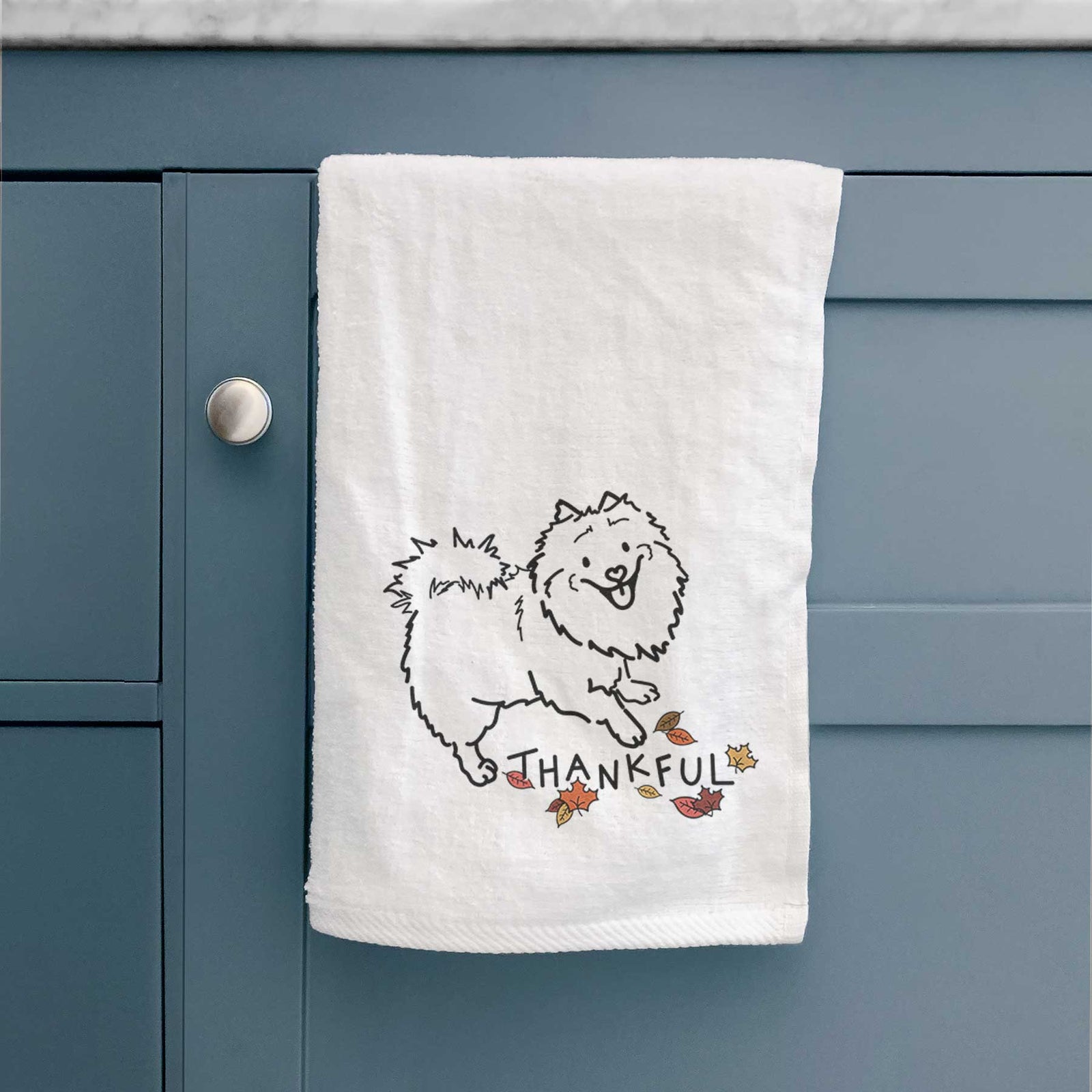 Minimalist line drawing of Goldie the Pomeranian Mix with 'Thankful' lettering on a decorative hand towel
