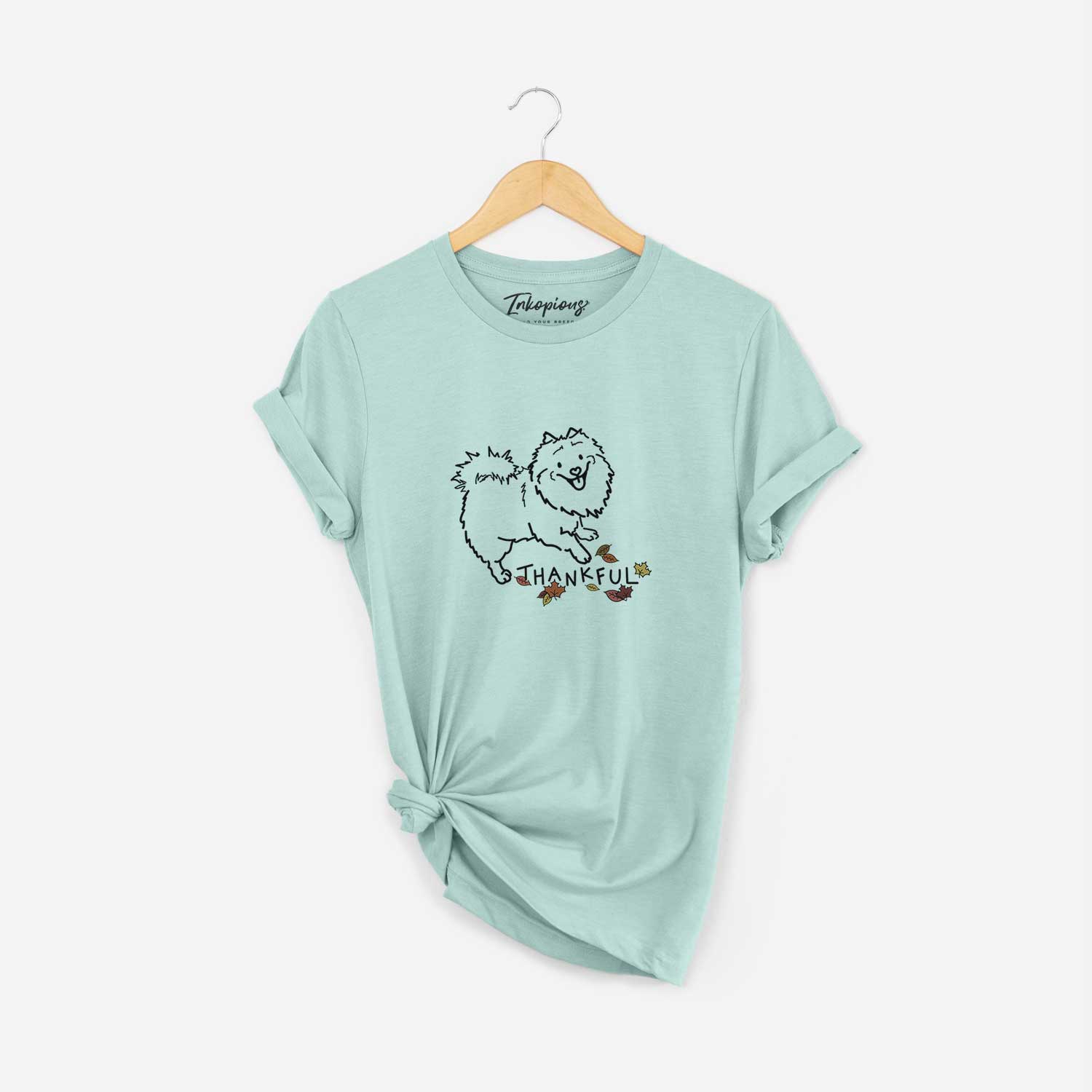 Minimalist line drawing of Goldie the Pomeranian Mix with 'Thankful' lettering on a Heather Sage Unisex crewneck