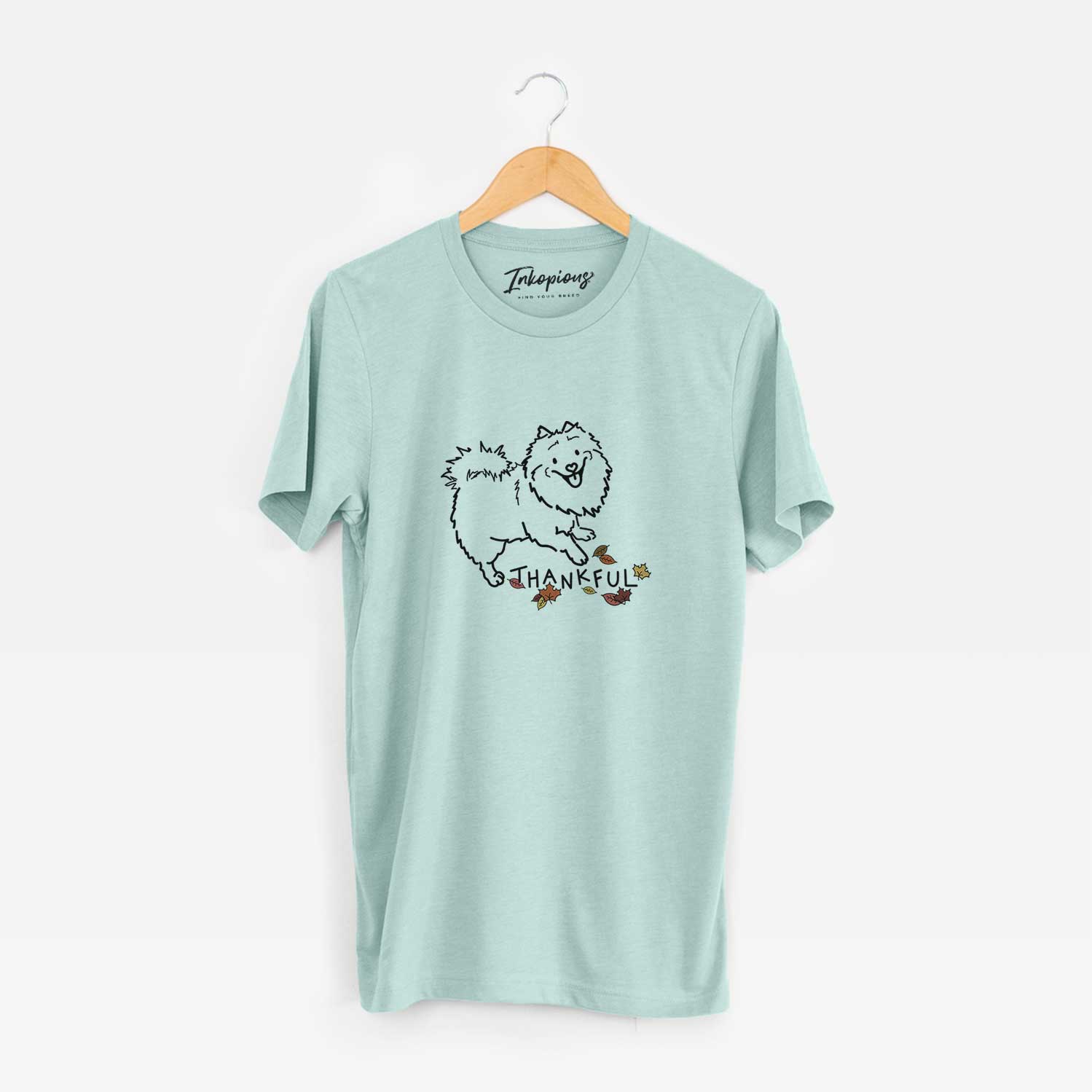 Minimalist line drawing of Goldie the Pomeranian Mix with 'Thankful' lettering on a Heather Sage Unisex crewneck